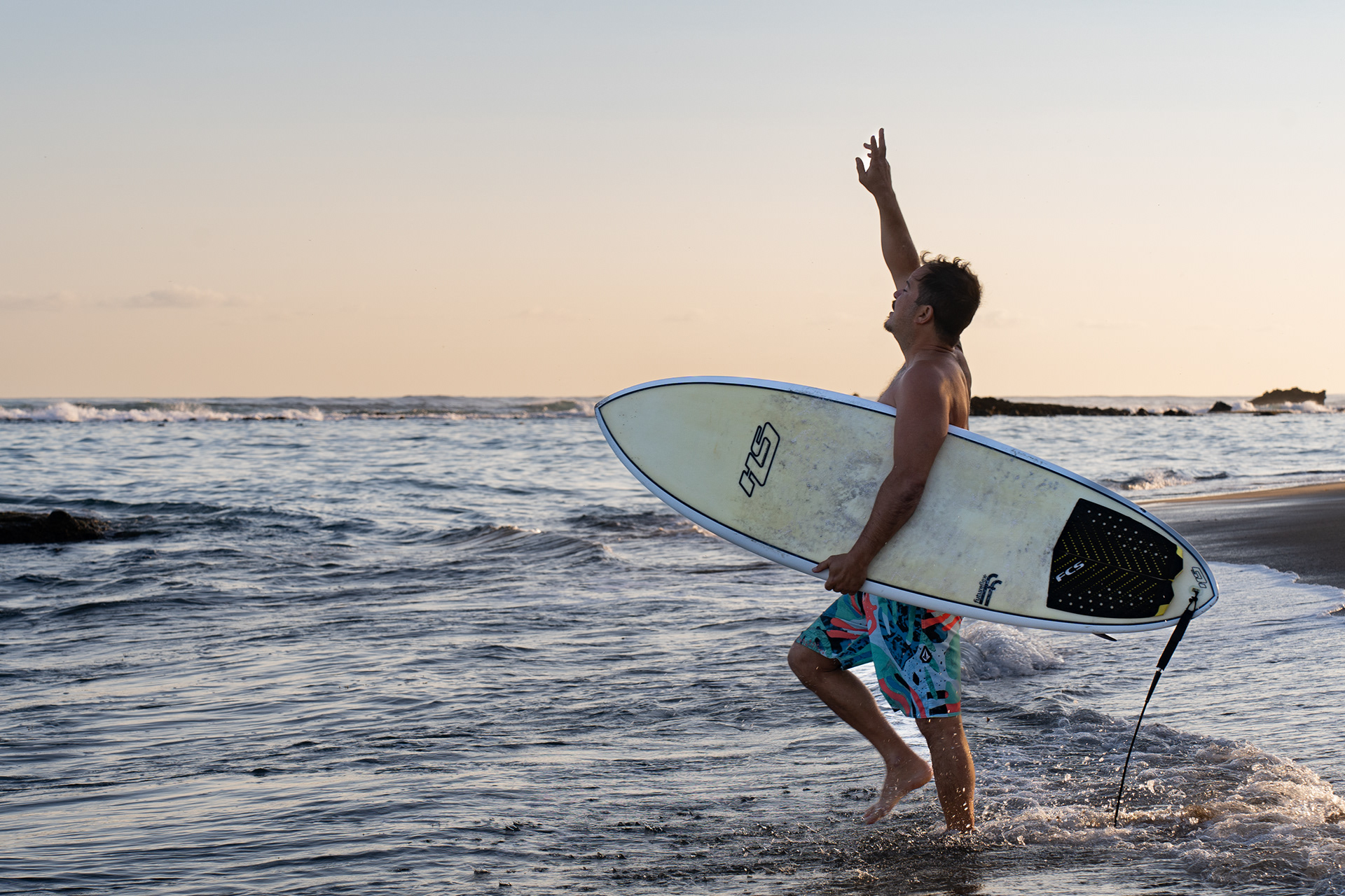 A surfer gives thanks as he enters the waves of Escambron Beach early in the morning on March 13, 2023. “All the surfers gather here. It’s a family, some of us have known each other for 50 years,” said local surfer Enrique Paoli. “We have waves elsewhere. This spot is sacred to us.” 