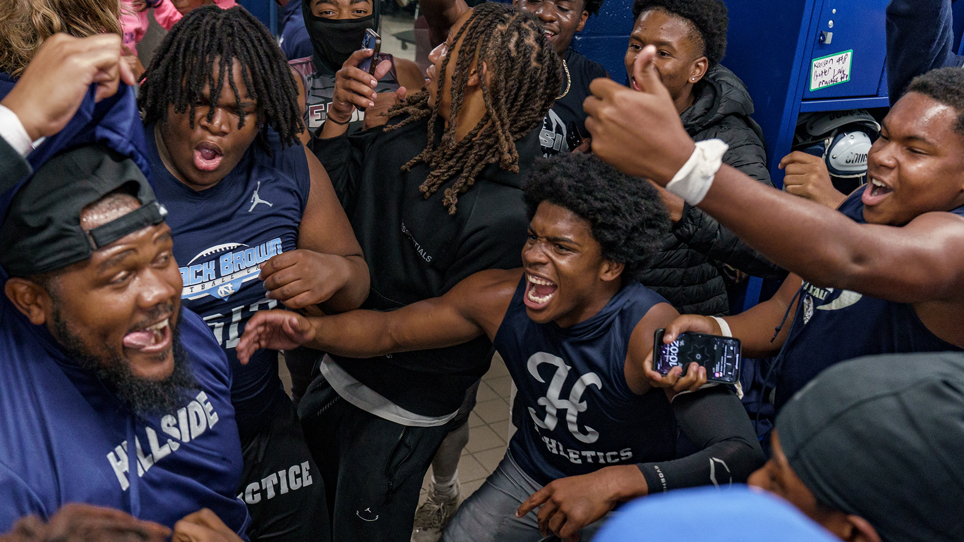 Hillside High School football head coach Torrey Nowell celebrates in the locker room with his team after winning the Durham-Chapel Hill Conference Championship in OT on Oct. 27, 2023. Nowell and his coaching staff led Hillside to a winning season despite it being their first year with the team. "I thought it was pretty cool to just celebrate with them," said Coach Nowell. "Just let them know I was proud of them."
