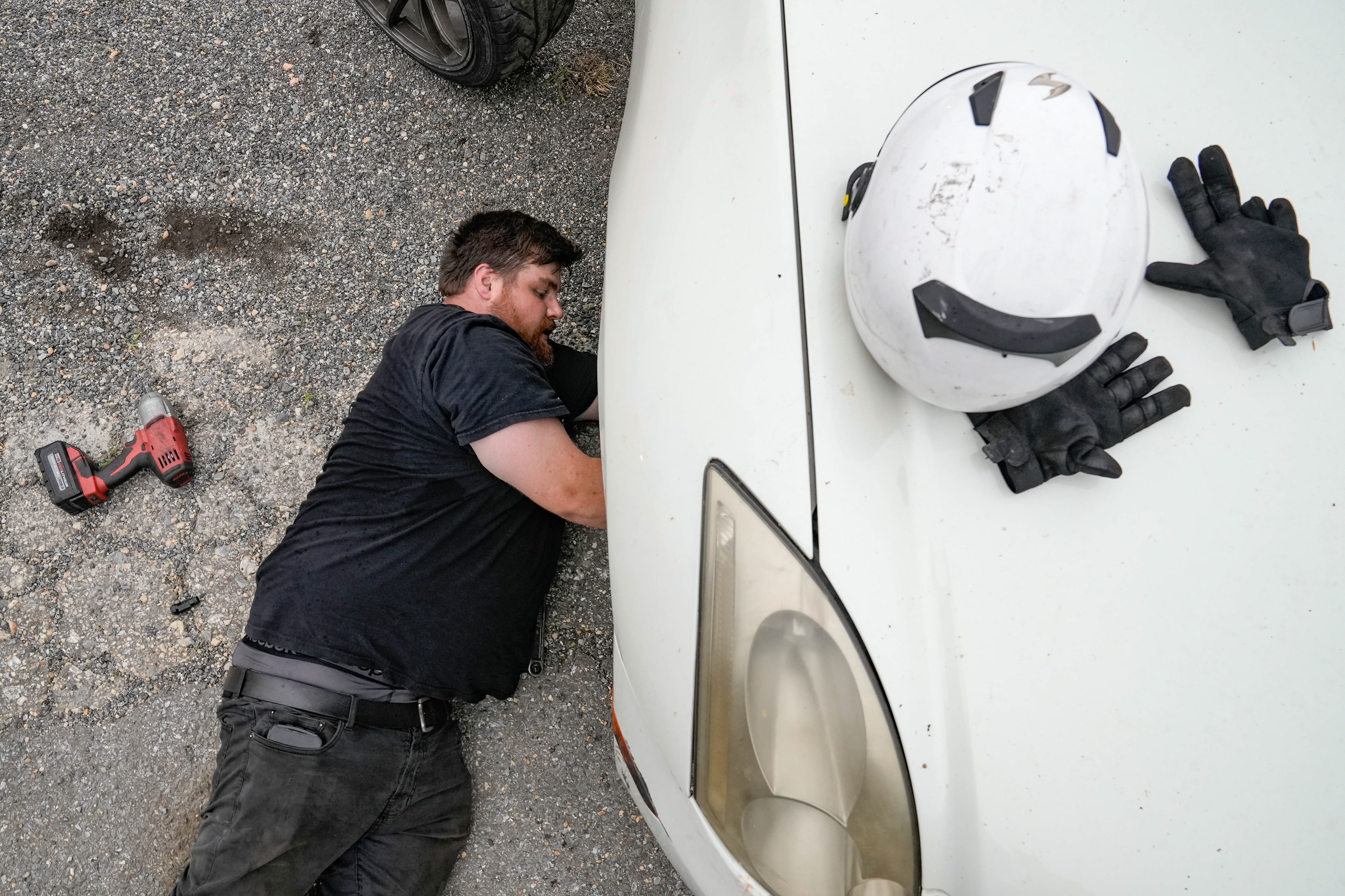 Zachary Cugle works on his car after damaging it at the grand opening of Capitol Raceway's new drift track in Crofton, MD on July 1, 2023.