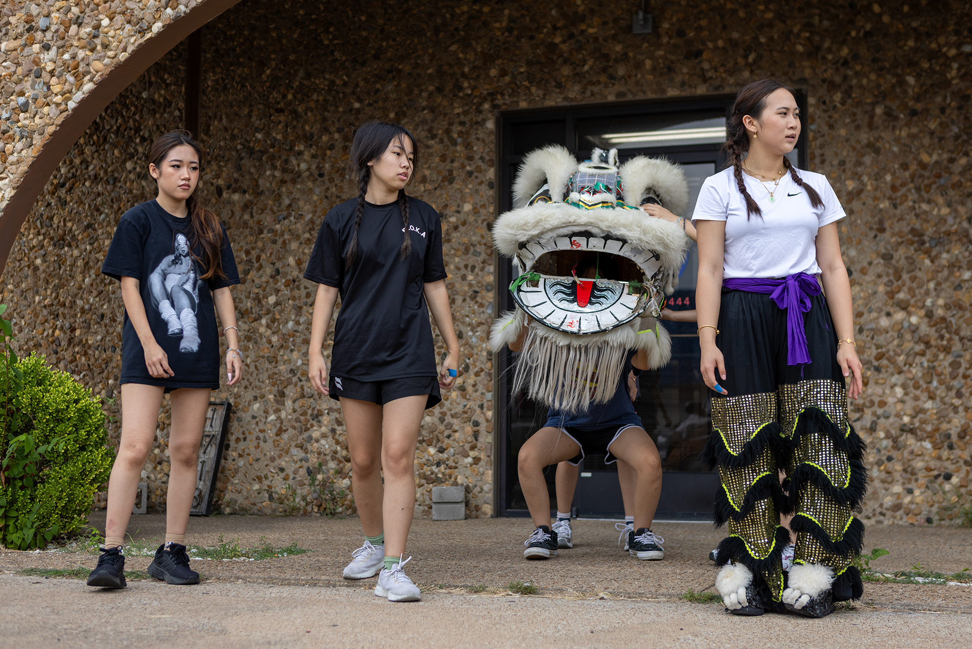 JL Lion Dance troupe members Alexa Ngo, Jocelyn Yang and co-captain Emily Chea watch new members practice head and tail formations in Garland, Texas on Oct. 18, 2025.