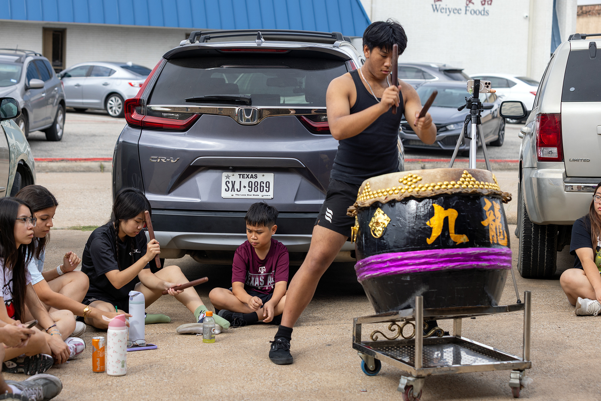 JL Lion Dance troupe member Jocelyn Yang (third from left) practices drumming outside of JL's training facility in Garland, Texas on Oct. 18, 2025.