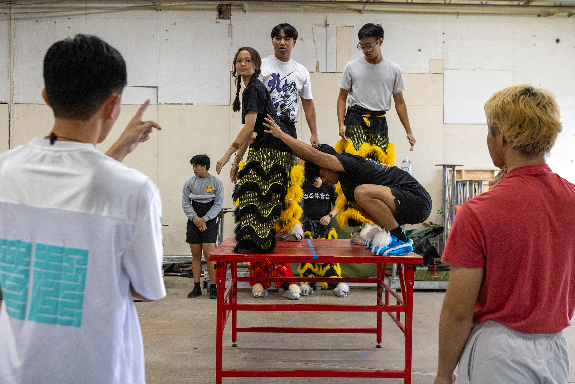 JL Lion Dance troupe member Evalena Davis (second from left) receives form critiques from master William Lee (bottom left) during practice in Garland, Texas on Oct. 18, 2025.