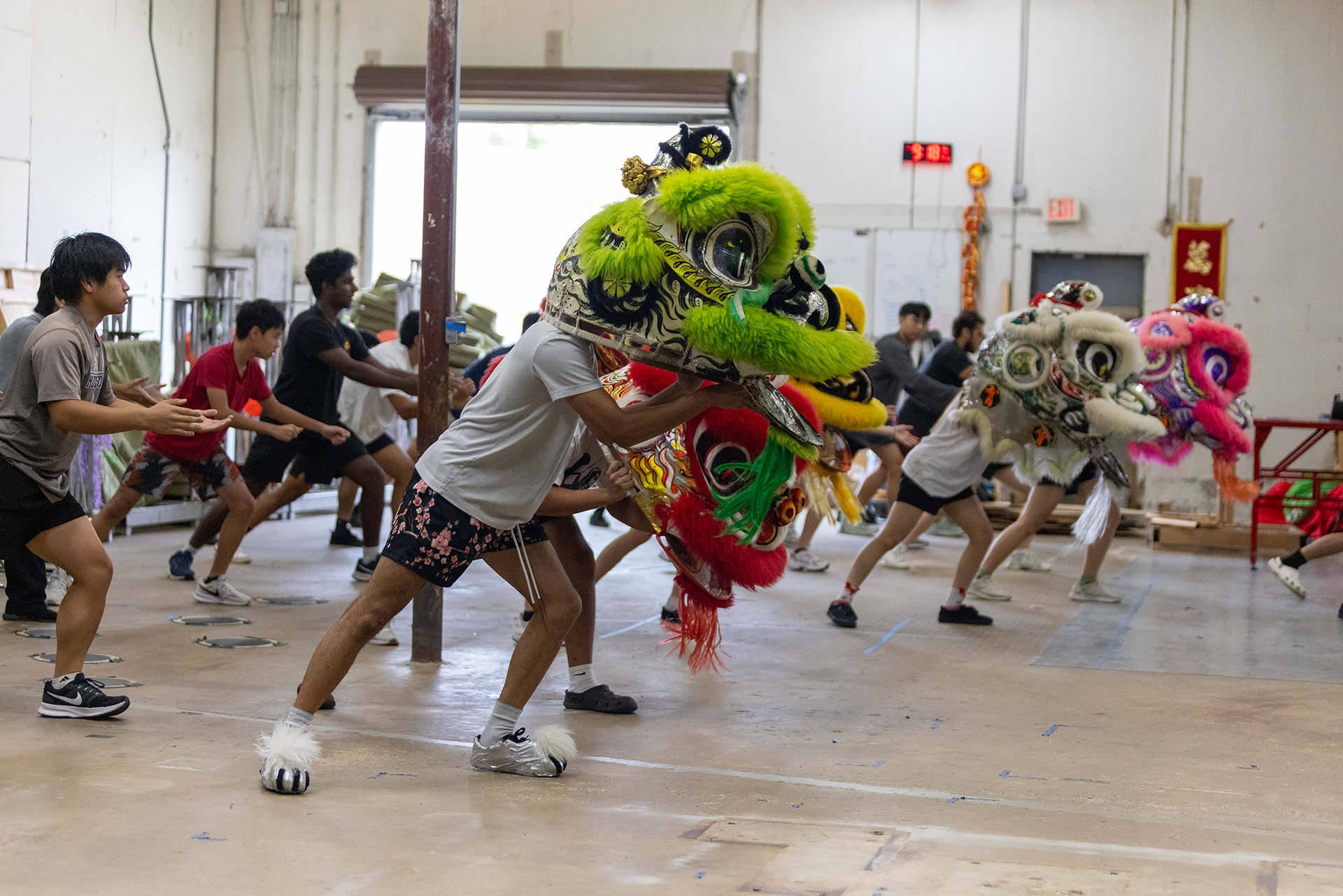 JL Lion Dance troupe members start their post-practice stretches in the Garland, Texas training facility on Nov. 18, 2025.
