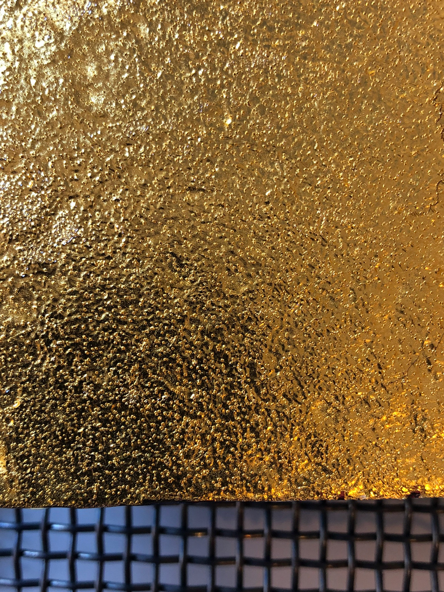 The perforated golden foil over copper.