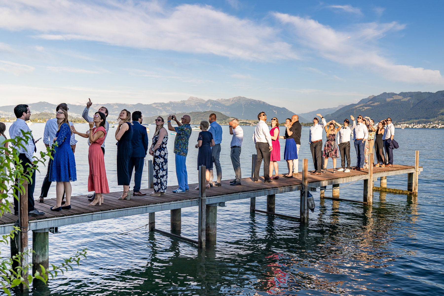 people standing on the piers during wedding looking at flugshow Suisse Patrouille