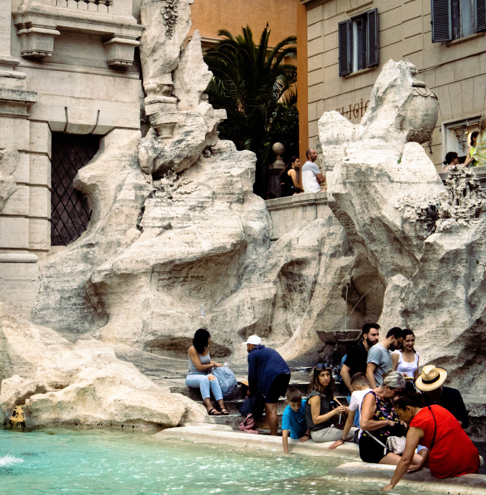 People sitting on the edge of the Trevi