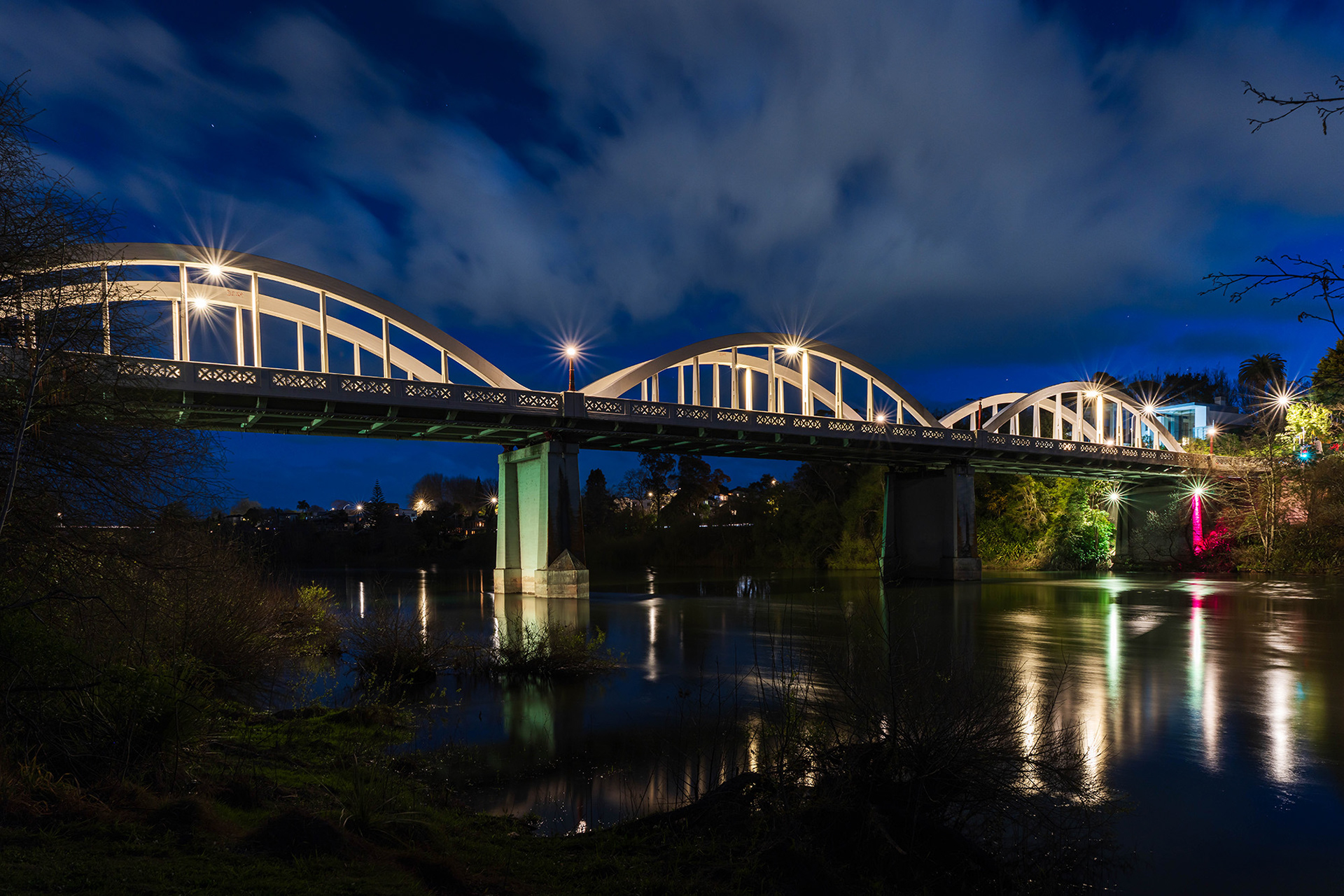 Fairfield Bridge after dark with lights reflected in the Waikato River