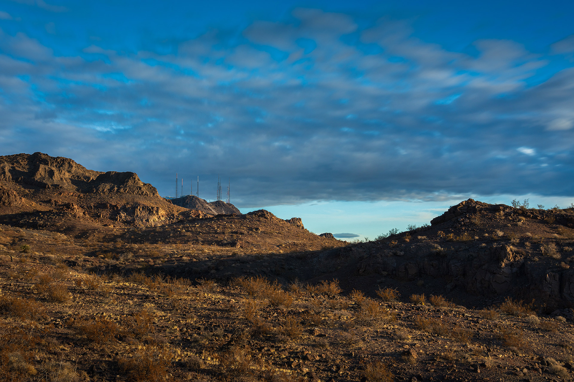 Cloudy and blue skies above the Black Mountain transmitter masts in the McCullough Hills