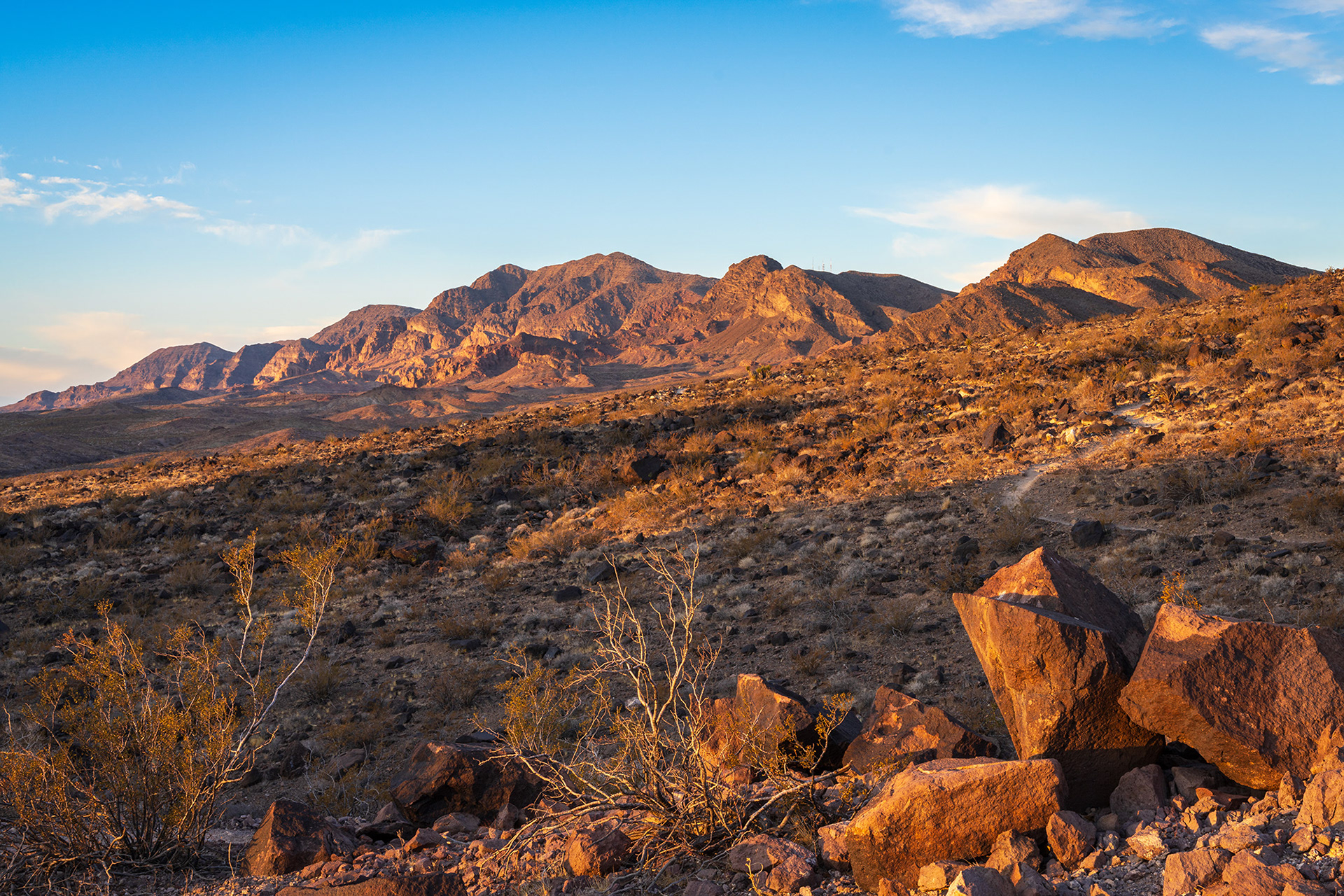 Early morning sunshine flooding over the rocky desert terrain with the McCullough Hills range in the background