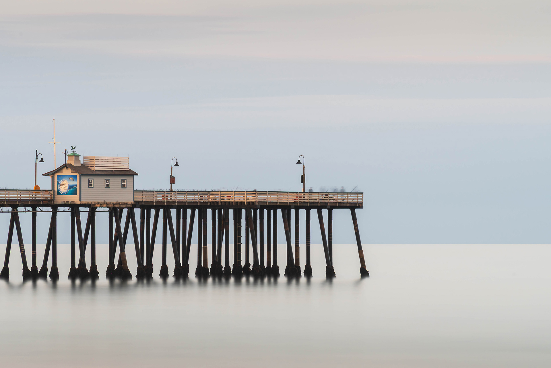 California seascape long exposure showing the end of San Clemente pier on a still but cloudy morning
