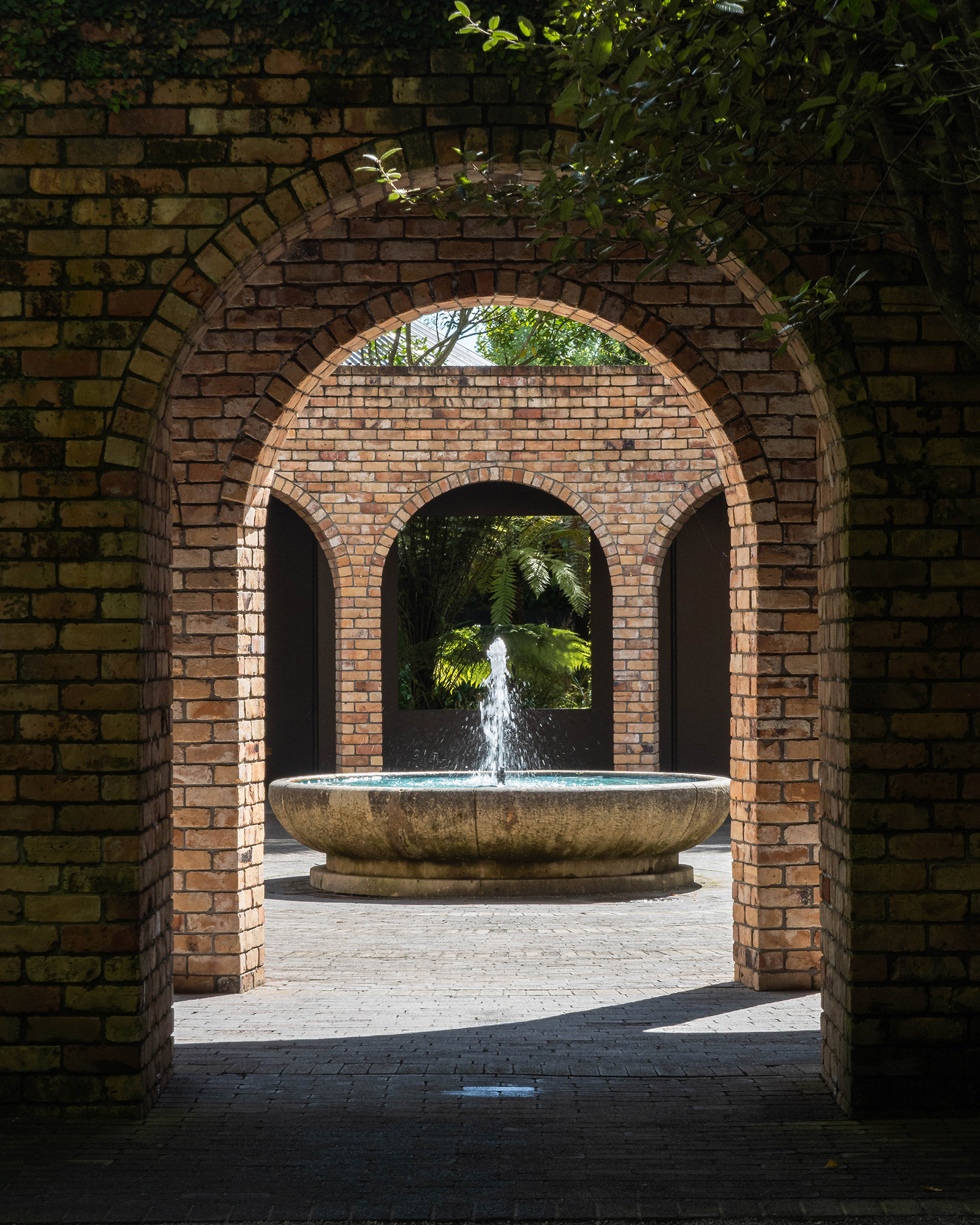View of a fountain at Hamilton Gardens framed by arches