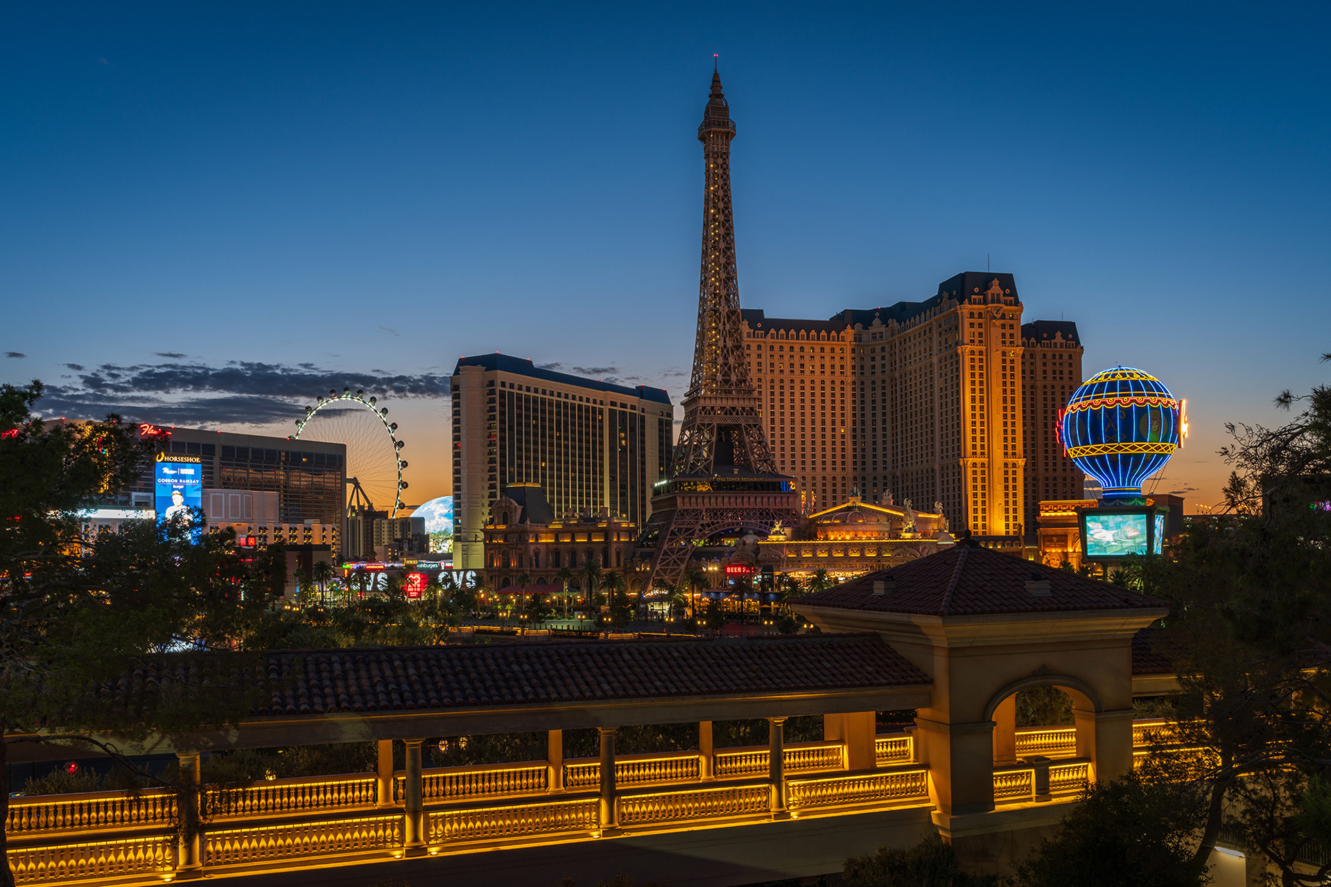 A view of Paris Las Vegas hotel with the Eiffel Tower and balloon in the pre-dawn light with the Bellagio walkway in the foreground
