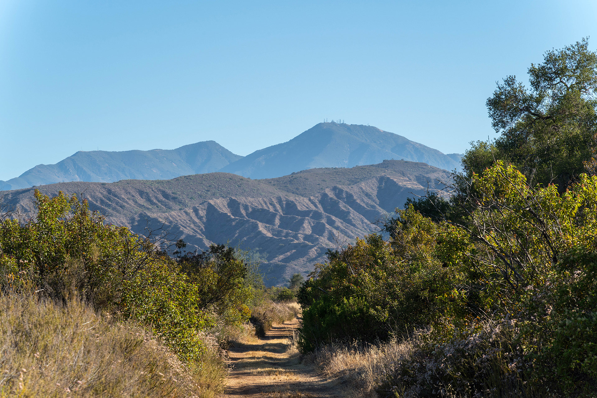 California landscape showing a trail heading away towards the distant Saddleback mountains