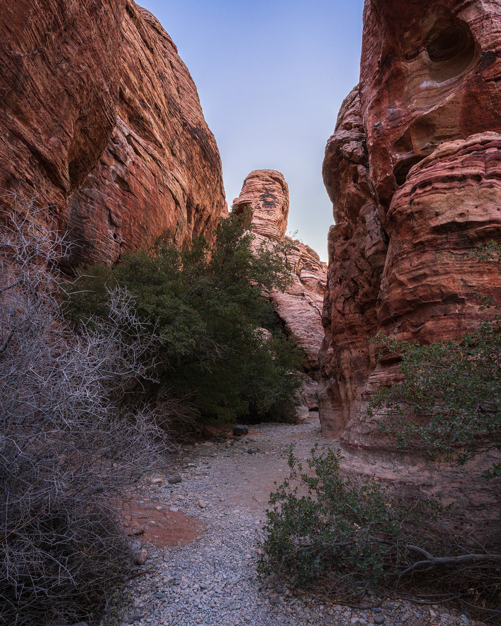 Calico Hills canyon wash running between tall and rugged sandstone rock formations.