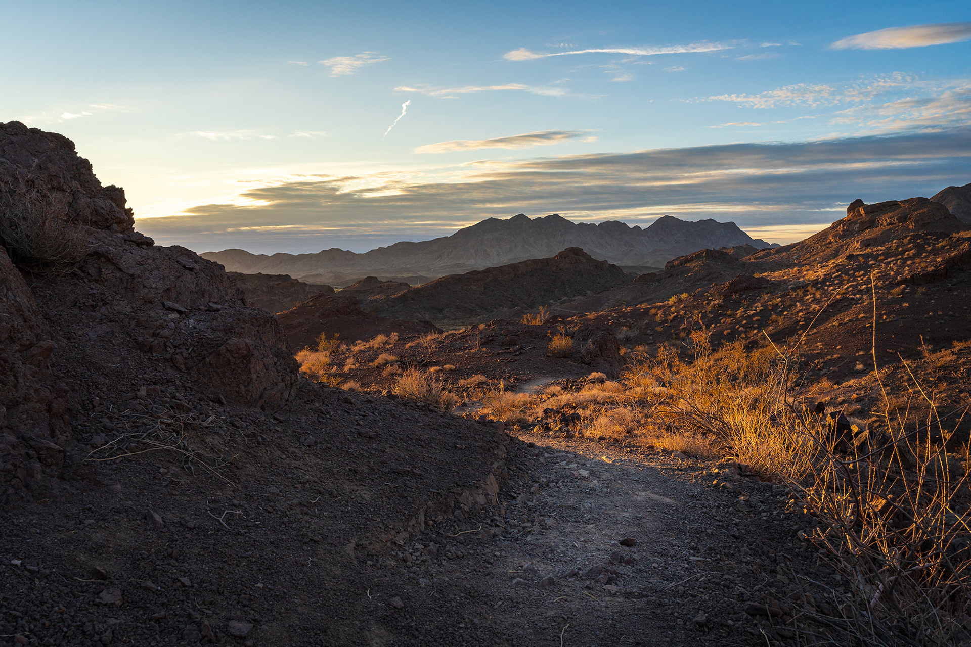 Early morning sunshine flooding over the rocky desert landscape of the McCullough Hills