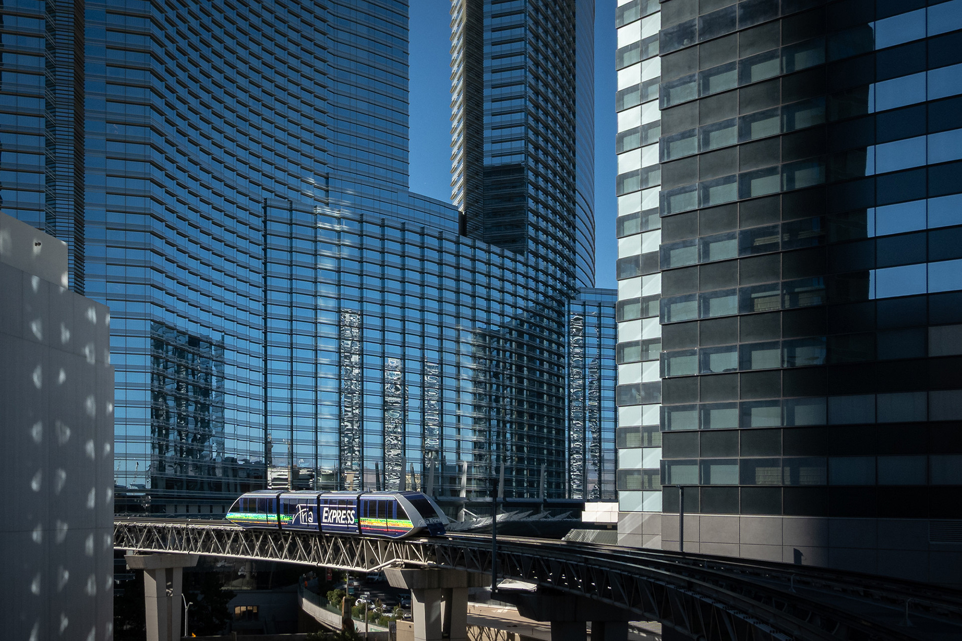 Aria Express tram making its way along the elevated track through the tall buildings of Las Vegas