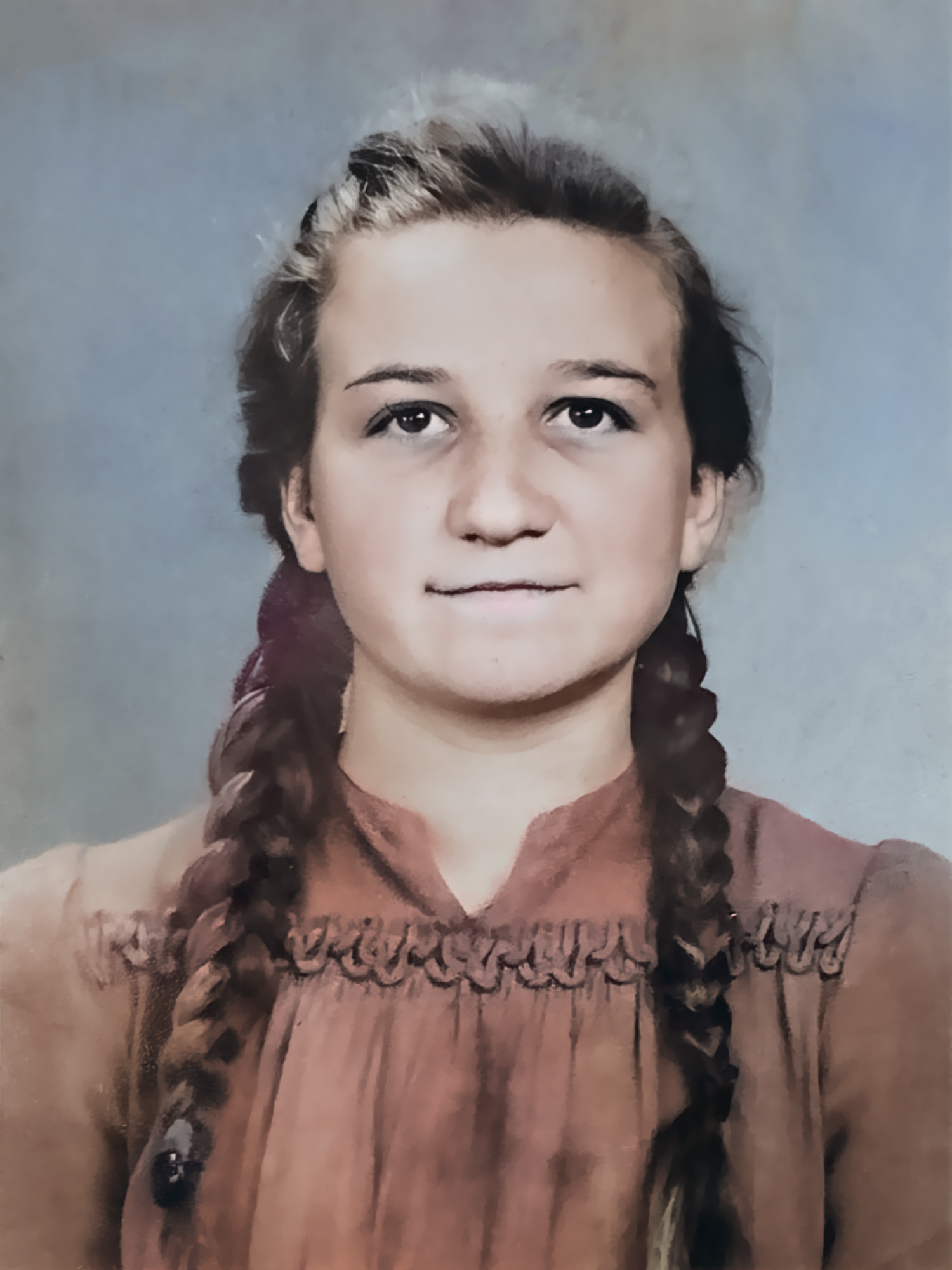 Koloryzowany portret młodej dziewczyny w stylu retro. Postać ma ciemne włosy zaplecione w dwa długie warkocze opadające na ramiona. Ubrana jest w ciemnoróżową lub brązową sukienkę z wysokim kołnierzem i ozdobnymi marszczeniami przy dekolcie. Tło jest jednolite, w odcieniach błękitu i szarości, przypominające dawne ekrany fotograficzne. Zdjęcie charakteryzuje się ziarnistością i miękkim wykończeniem typowym dla technik renowacji starych fotografii.