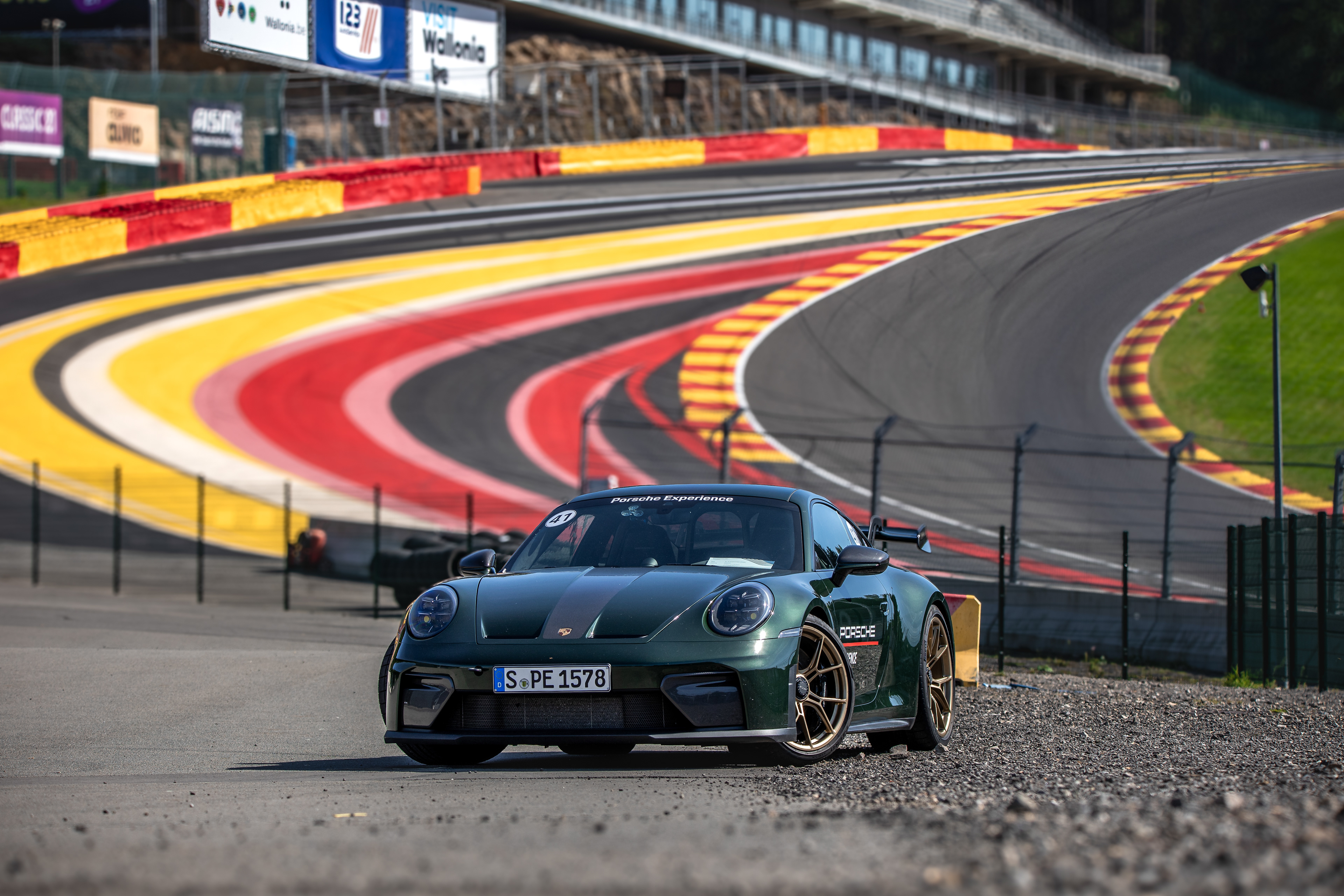 Porsche 911 ścigające się na torze Spa-Francorchamps podczas dynamicznej sesji motoryzacyjnej