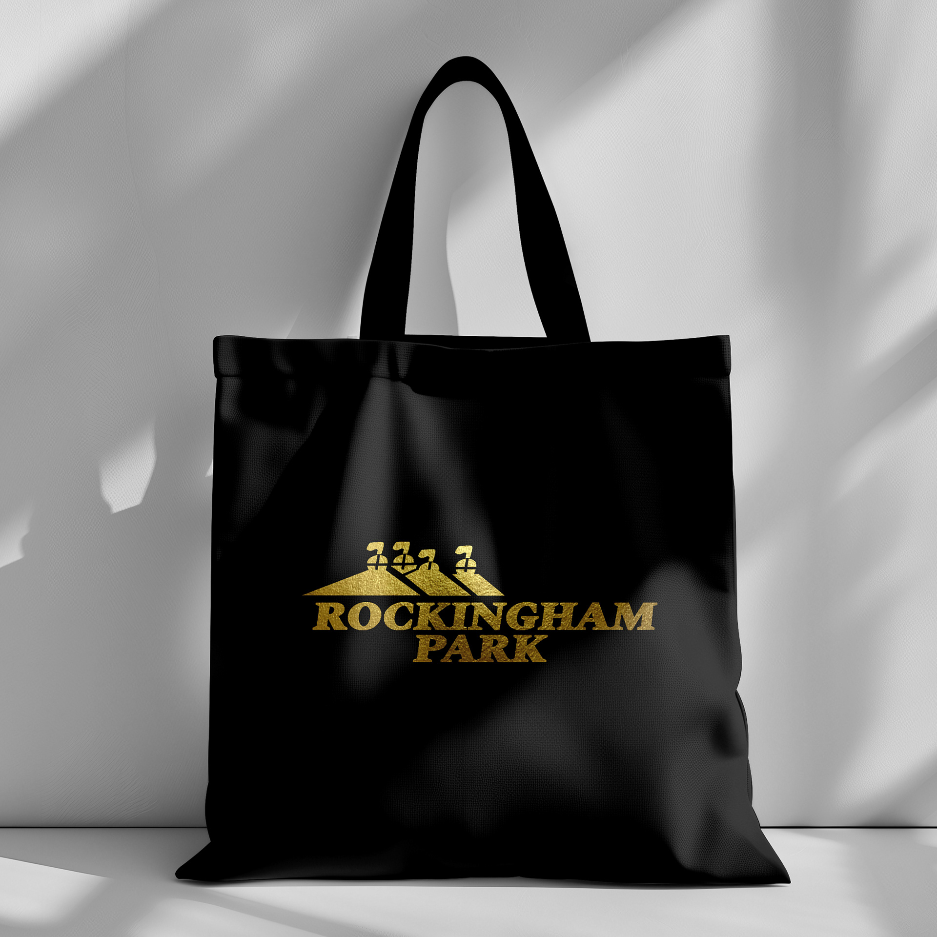 Custom-designed metallic gold logo applied to a sleek black tote showcasing professional brand identity work and premium print-ready files.