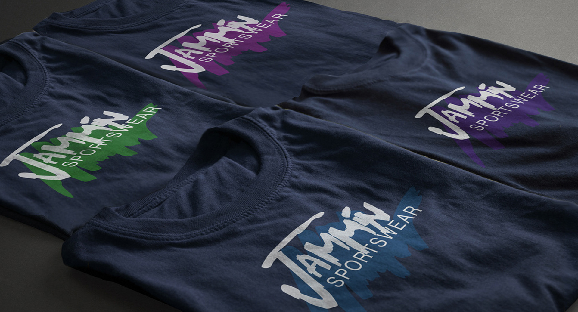 Business logo printed in four color variations on neatly folded navy T-shirts, fresh off the press