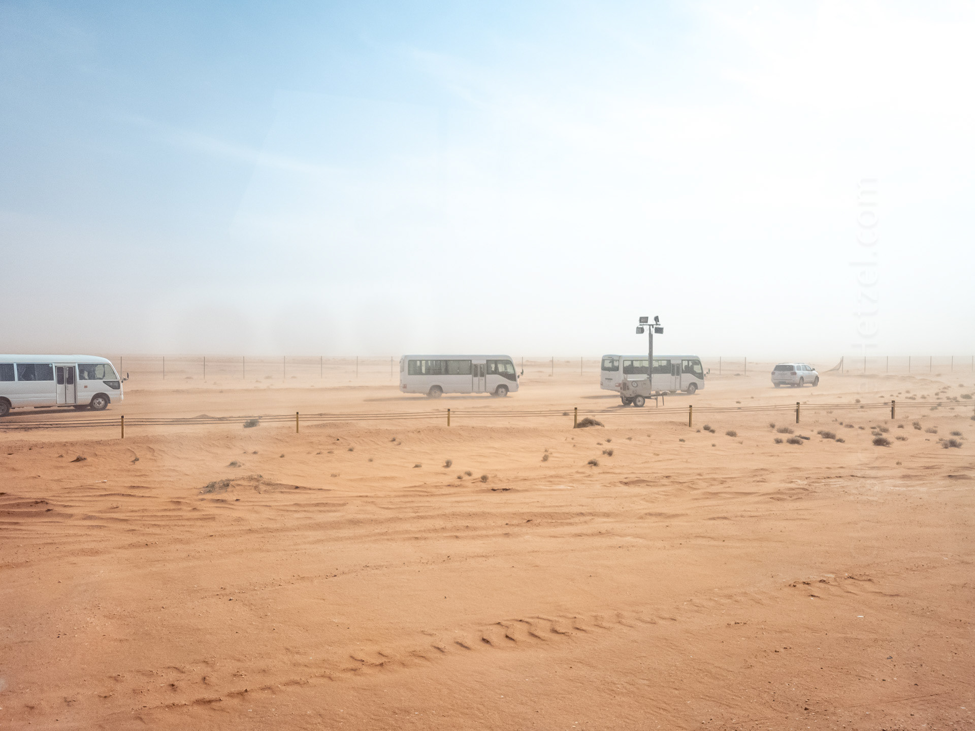 When we arrived in the morning, the wind was blowing so fiercely that it was almost sandstorm-level conditions. This is a view of our caravan of buses, after turning off the main (paved) highway towards the festival grounds.