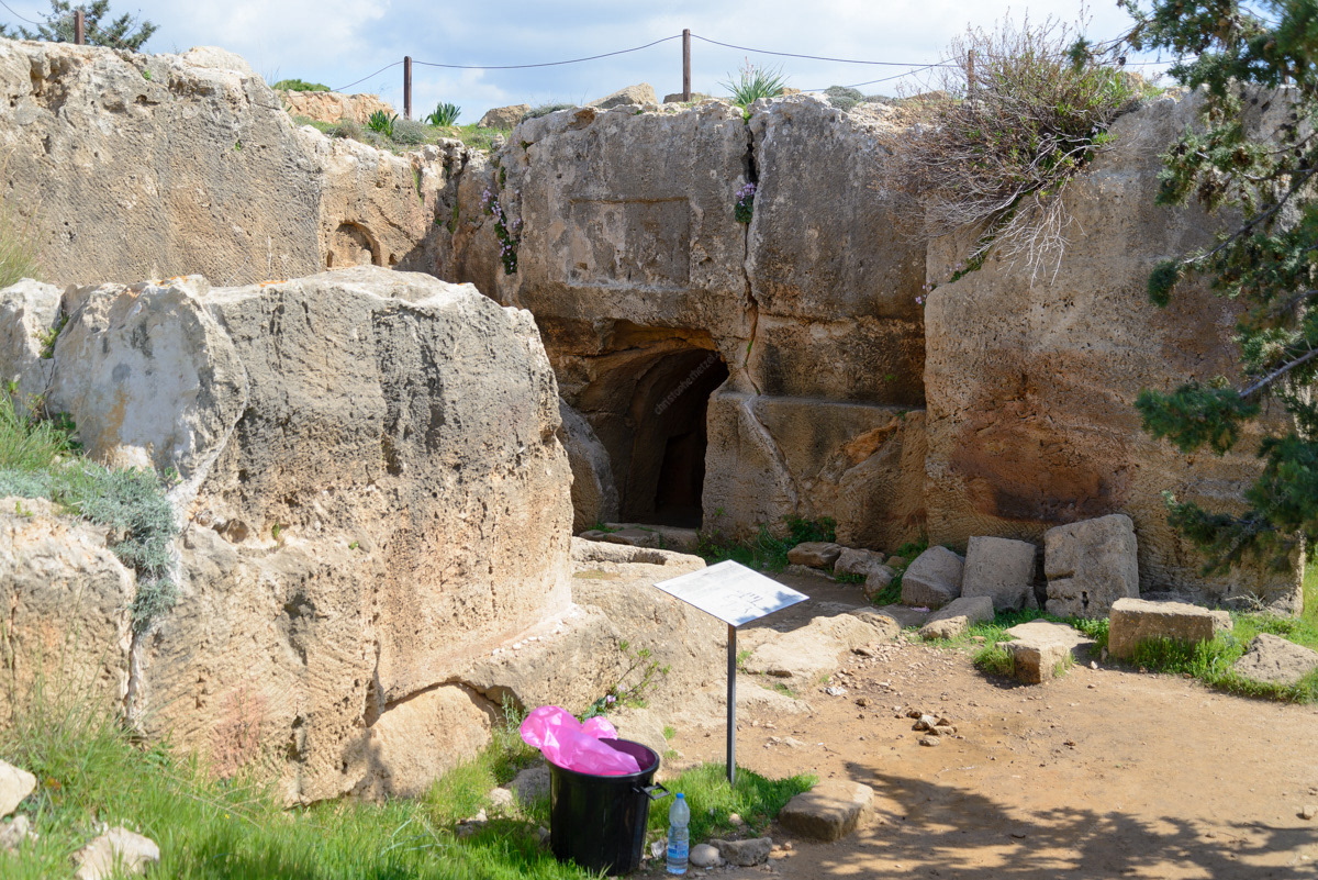 This photo shows how much Tomb #2 was damaged by quarrying through the years. Gone are the roof over the atrium and its south wall. The water well is in the foreground, just behind the interpretative panel, and the burial tomb is in the background. The dromos is behind the stone wall on the left, and the tomb's original south wall (and location of a later entrance) was in the now open space on the right.