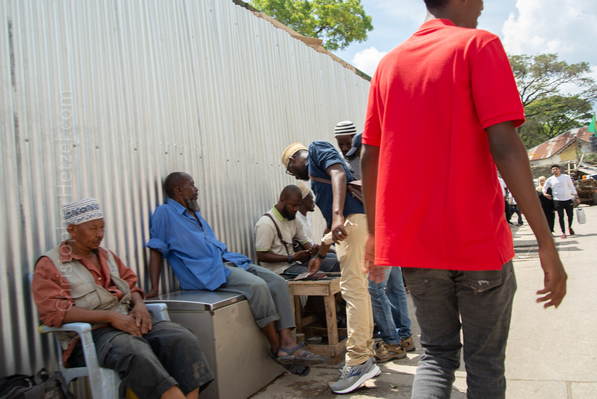 Men selling cell phones outside the Stone Town Market.