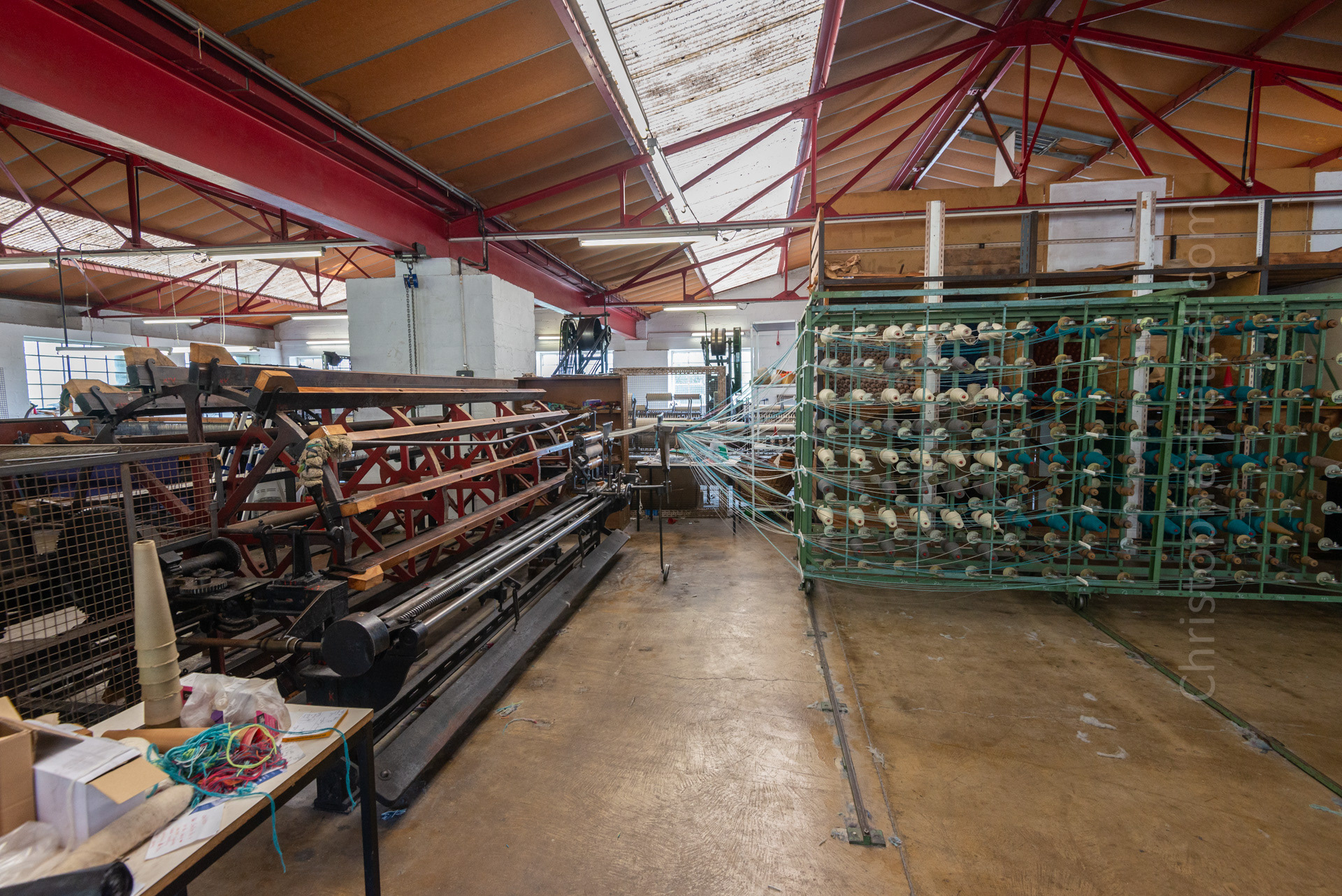 Warping - To prepare for weaving, threads of yarn are transferred from cones to bobbins, which fit into the shuttles of the weaving machines. Meanwhile, a warping machine arranges the threads to form the warp. This image shows the latter process.