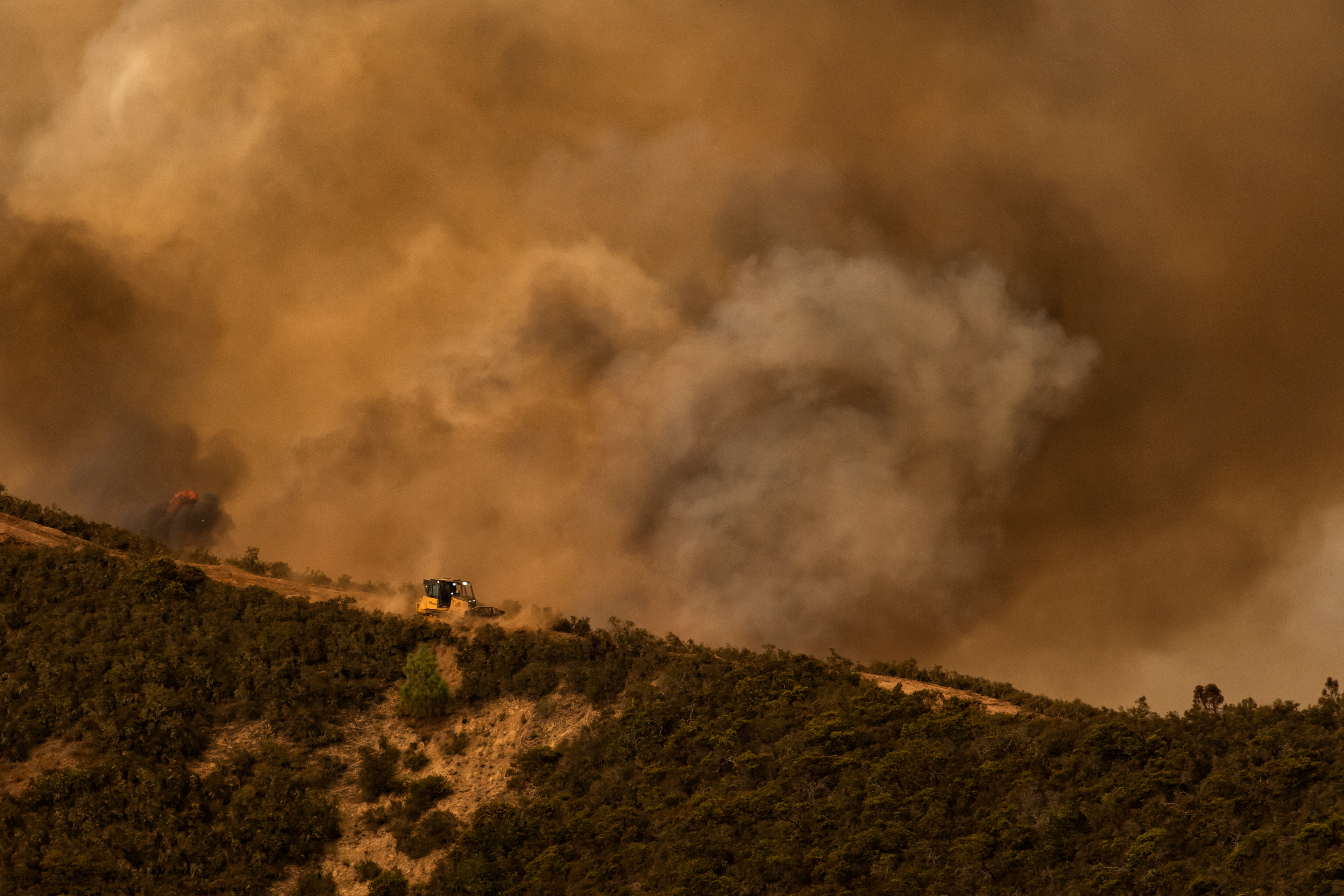 A dozer operator clears a fire break on a ridge near San Benancio road.