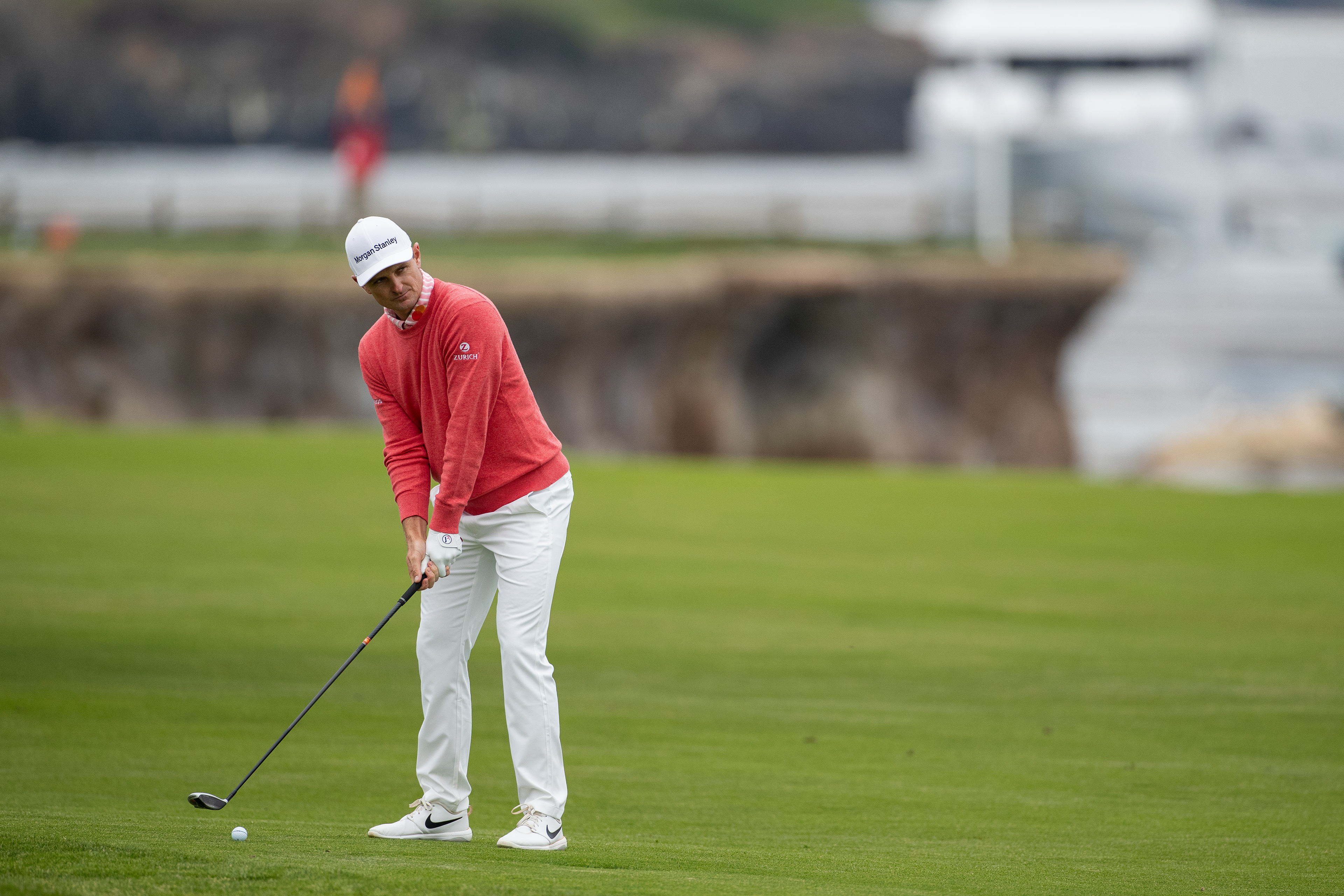 Justin Rose prepares to hit a fairway shot on hole 18