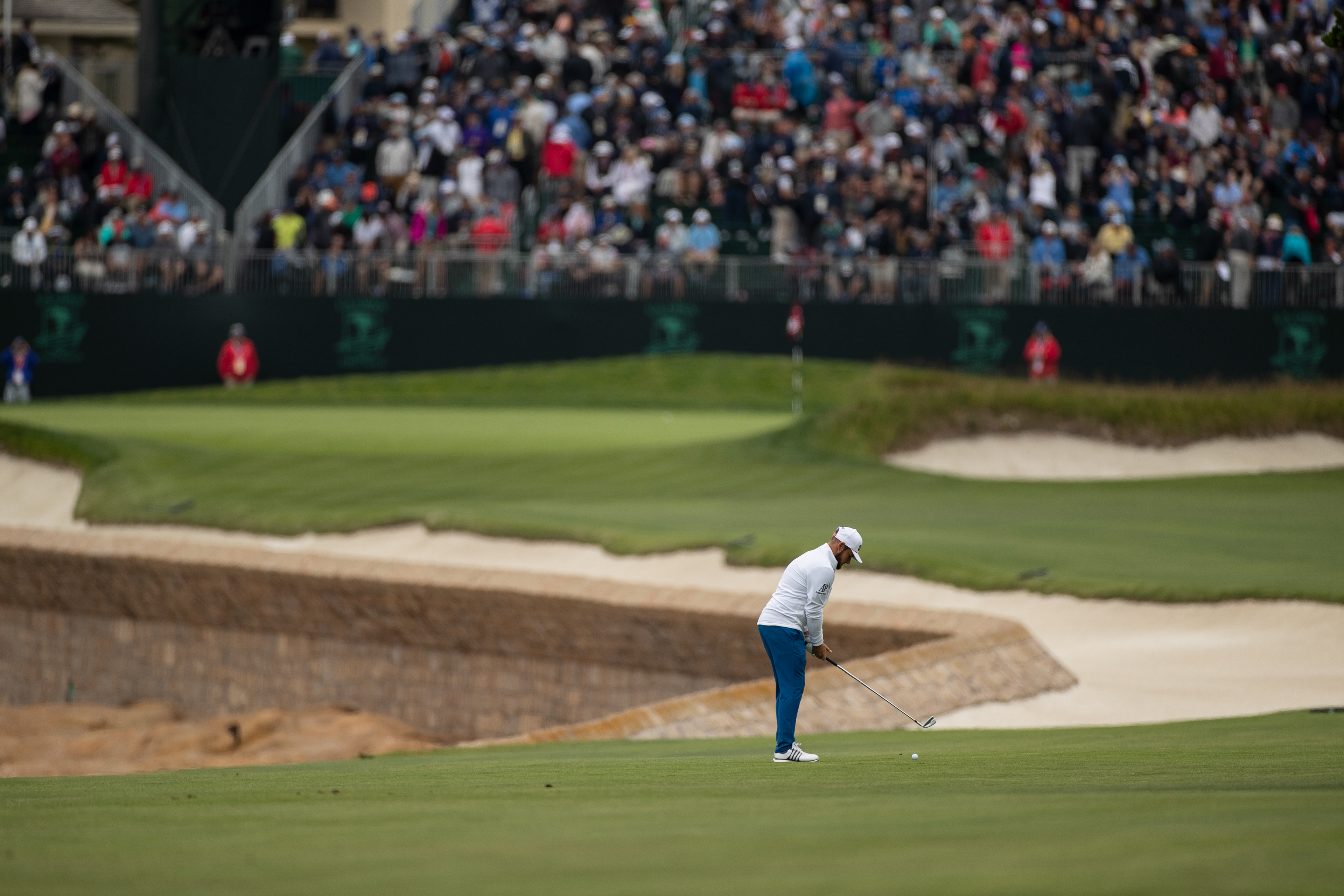 Tyrrell Hatton prepares to hit an iron shot to the 18th green