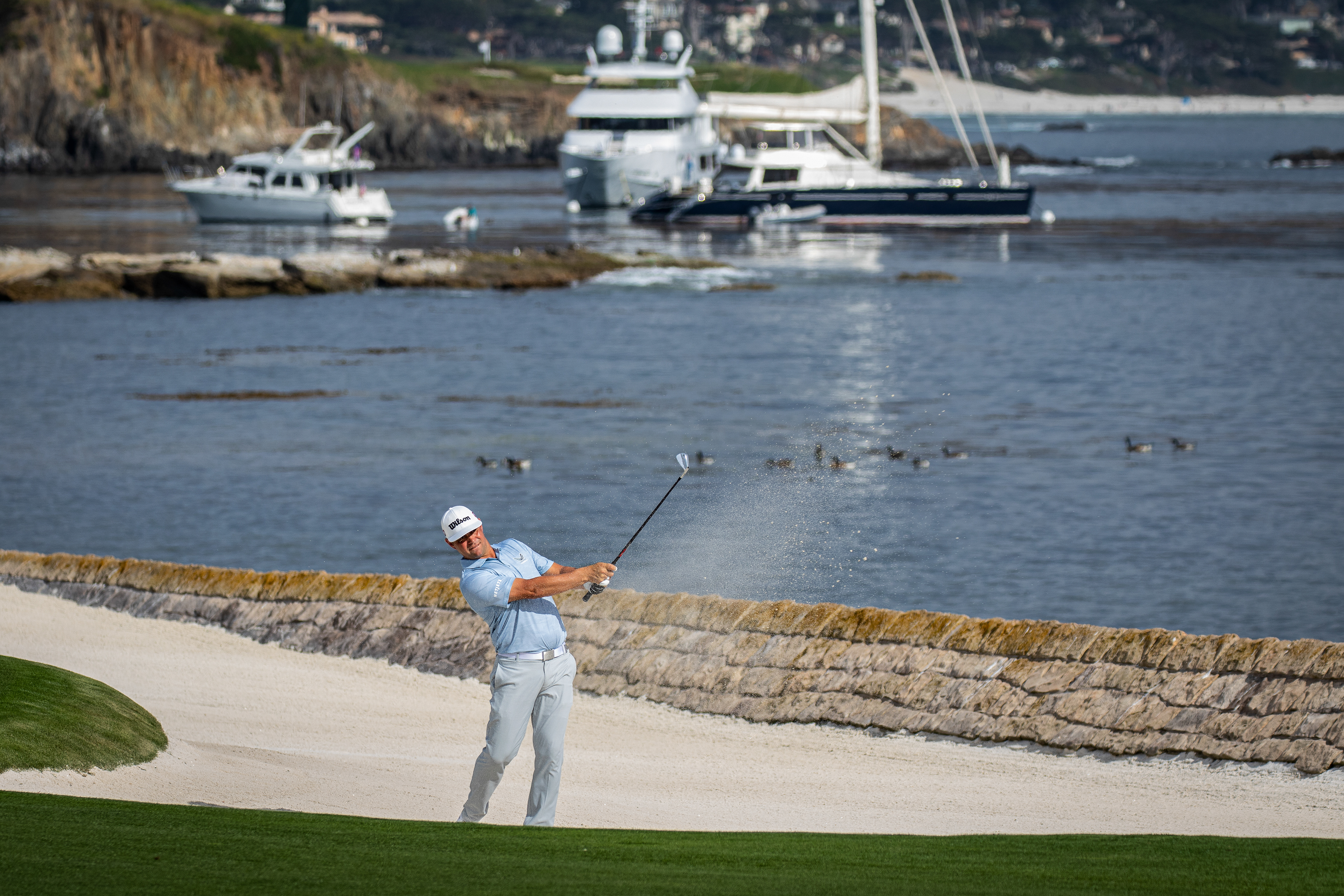 2019 U.S. Open champion Gary Woodland hits a bunker shot to the 18th green