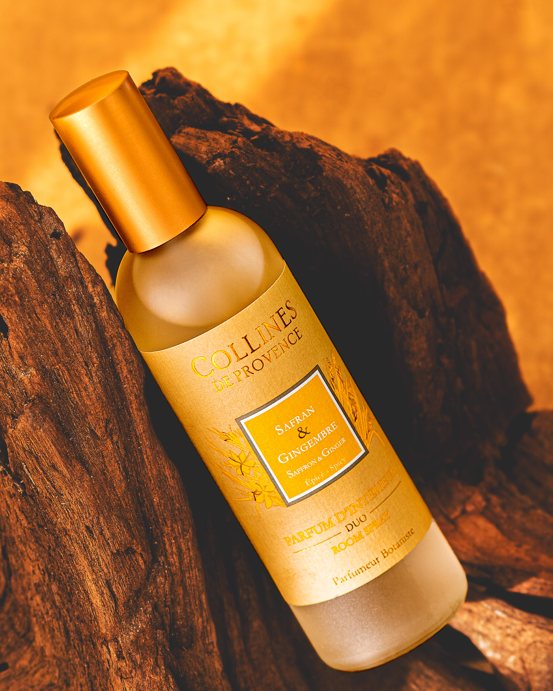 flacon de parfum d'intérieur senteur safran et gingembre de la marque Collines de Provence pose sur du bois.