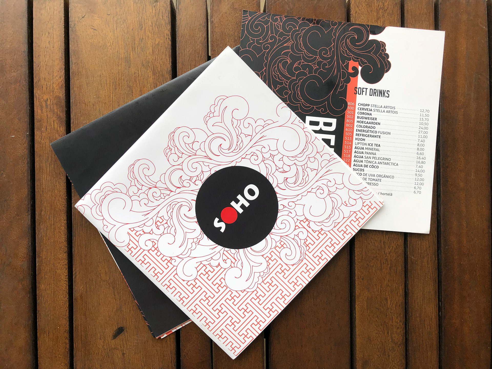 Menu fechado por dobras, acompanhado por um adendo de menu de bebidas