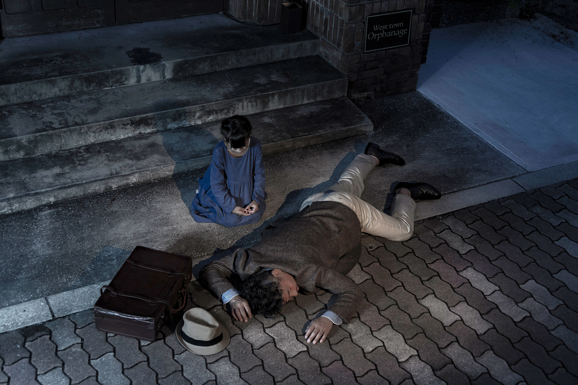 A man is lying under the window of the orphanage. It's my father.