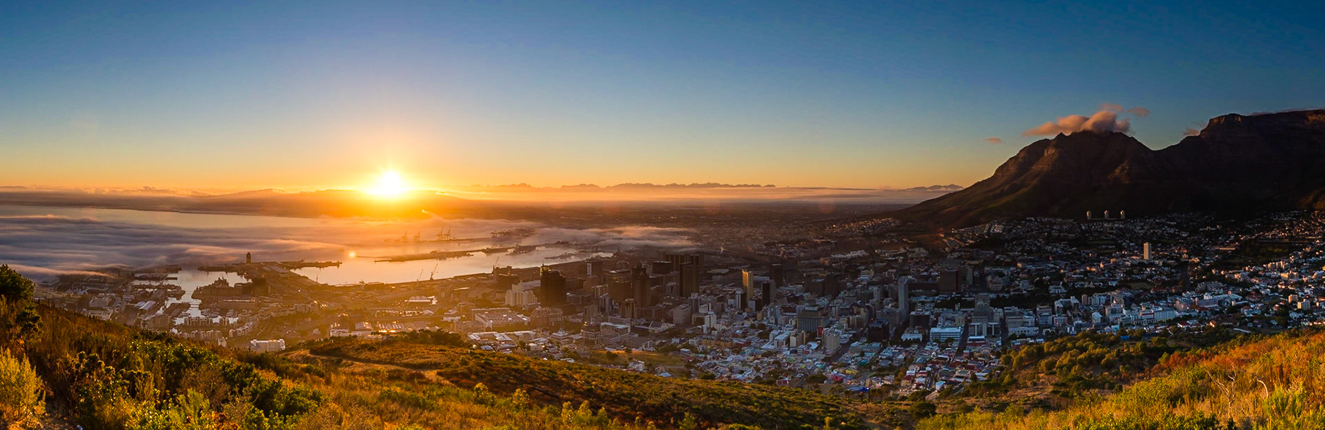 Taken from near the top of Signal Hill, Cape Town, I cought the beautiful moment the sun broke over the distant hills.This cropped panorama comprises of 9 images.