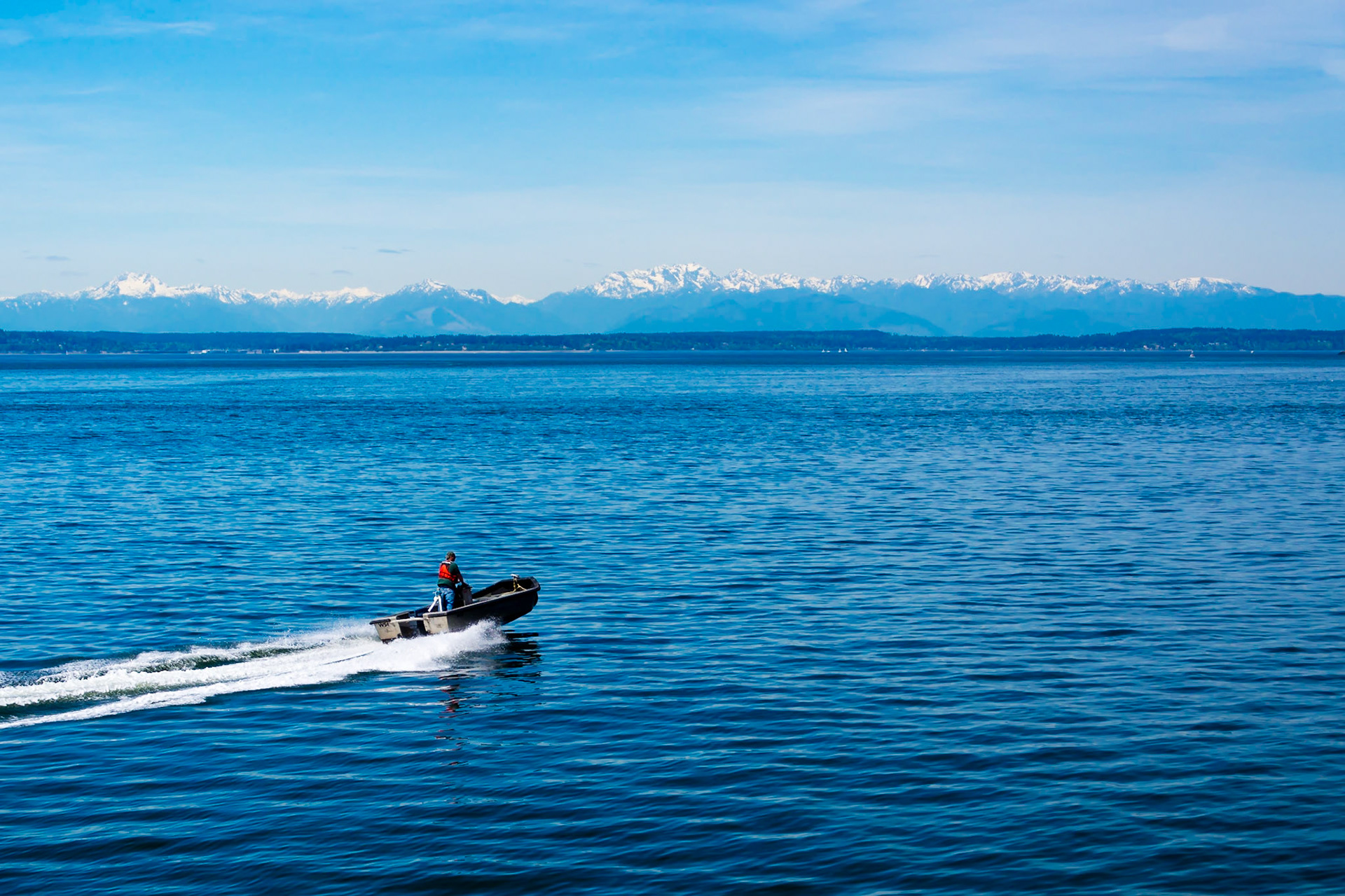 A beautiful day in Seattle- the sky is clear, the sea is calm and this guy has the whole bay to himself.