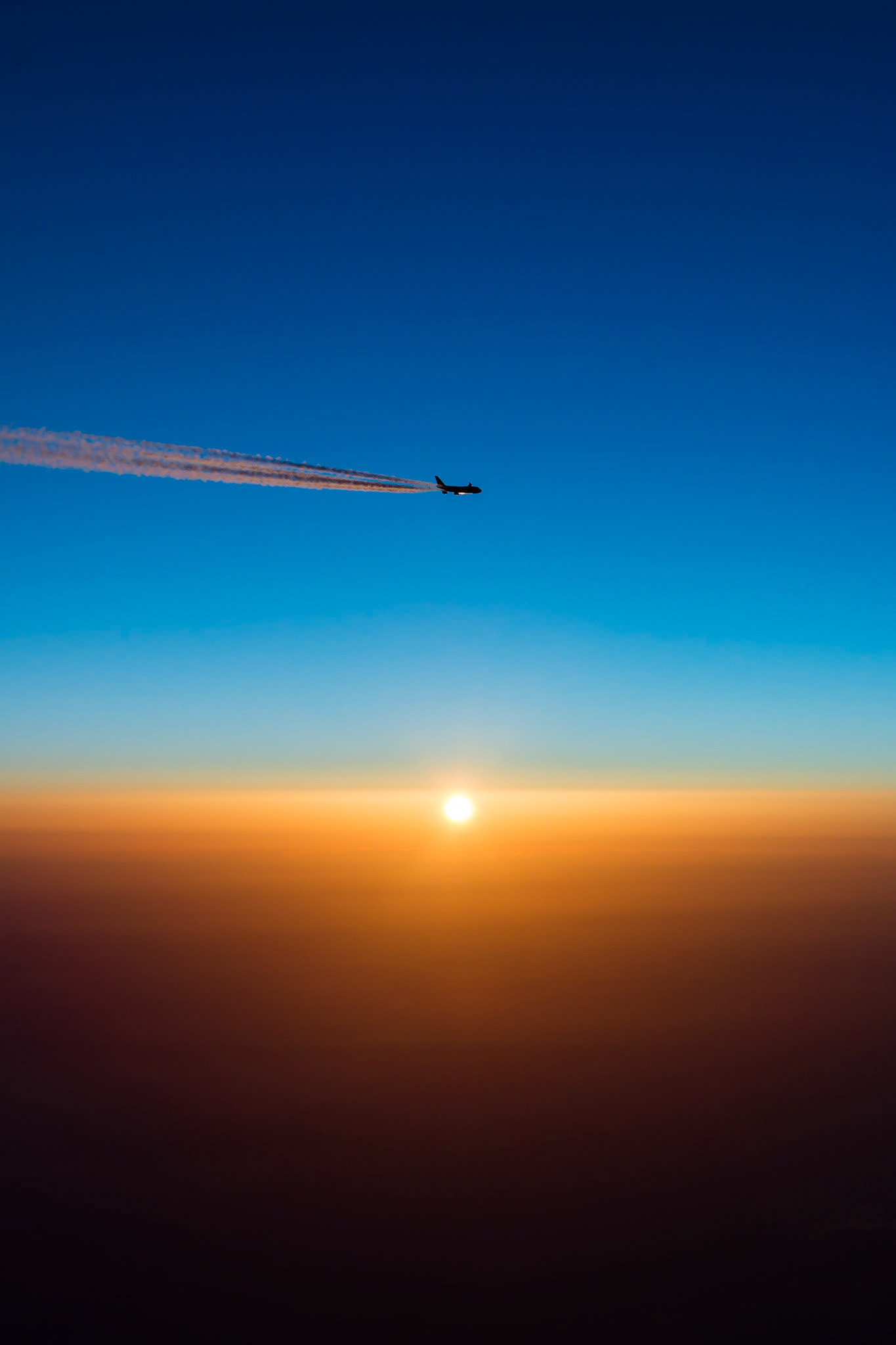 This was a once-in-a-lifetime photo. We were flying from Houston to Dubai, approaching the southern tip of Greenland at sunrise, just about to enter North Atlantic airspace. This British Airways 747 Jumbo Jet was just ahead on exactly the same airway.  I could see the scene developing and as we entered the airspace he offset 1nm right and we offset 2nm right (a standard procedure over the ocean) - and as the sun rose it was perfect!