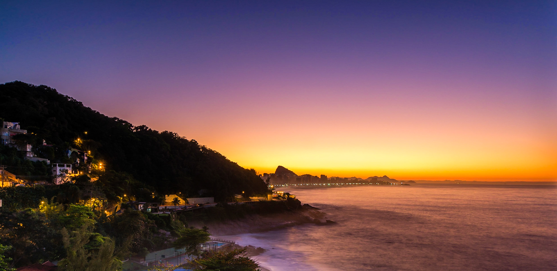 Sunrise in Rio, capturing Ipanema Beach, the town of Leblon and Sugarloaf Mountain.