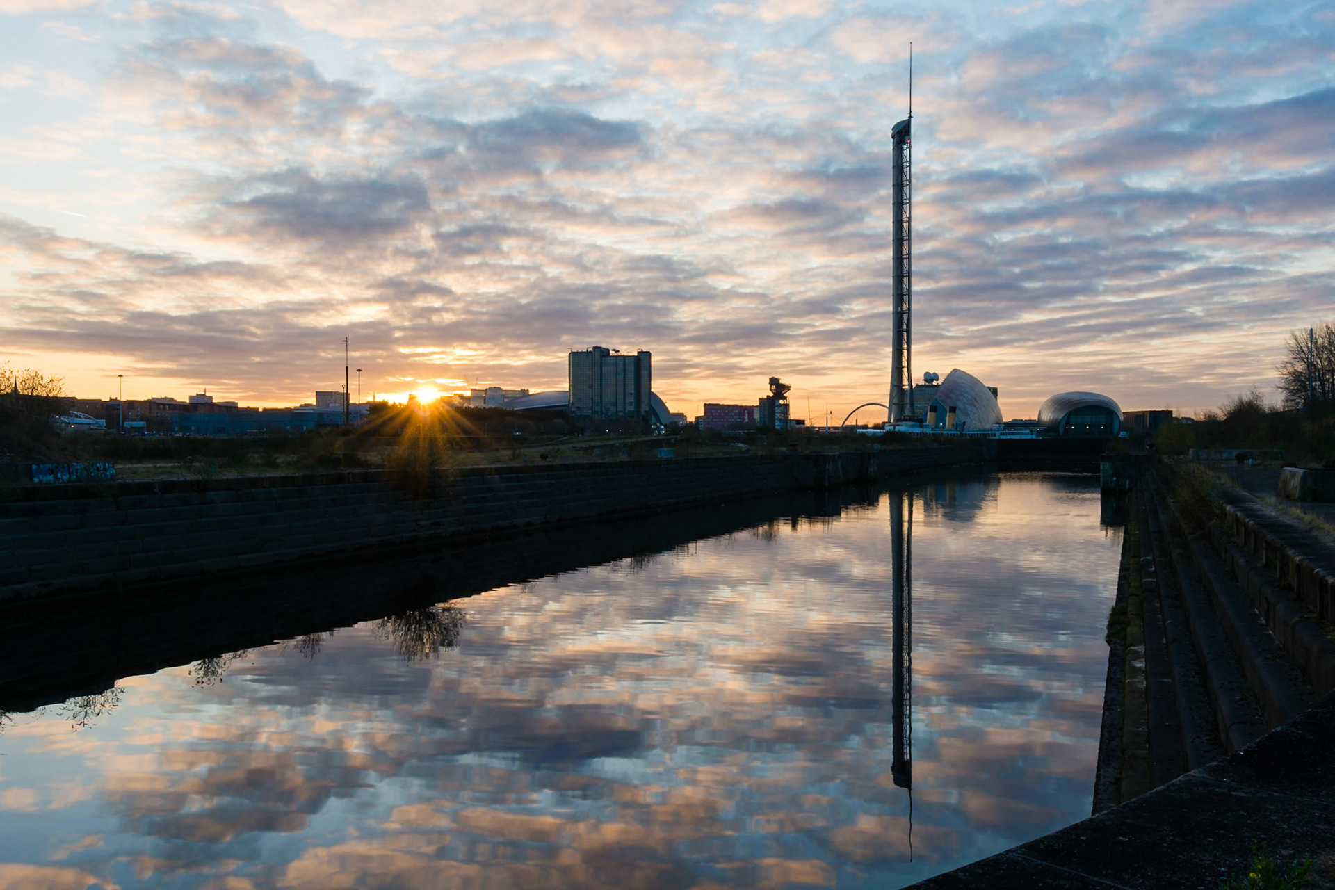 Sunrise over the abandoned and derelict Govan Dry  Docks inGlasgow, UK. The view looks towards the regenerated area of Pacific Quay, including the Glasgow Tower and BBC Scotland office.