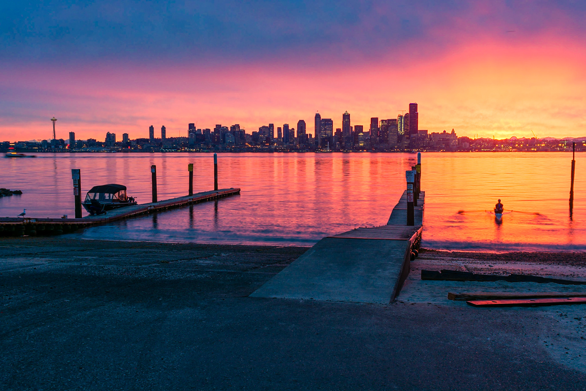 This gentleman is beginning a early-morning row while a stunning sunrise illuminates the skyline.