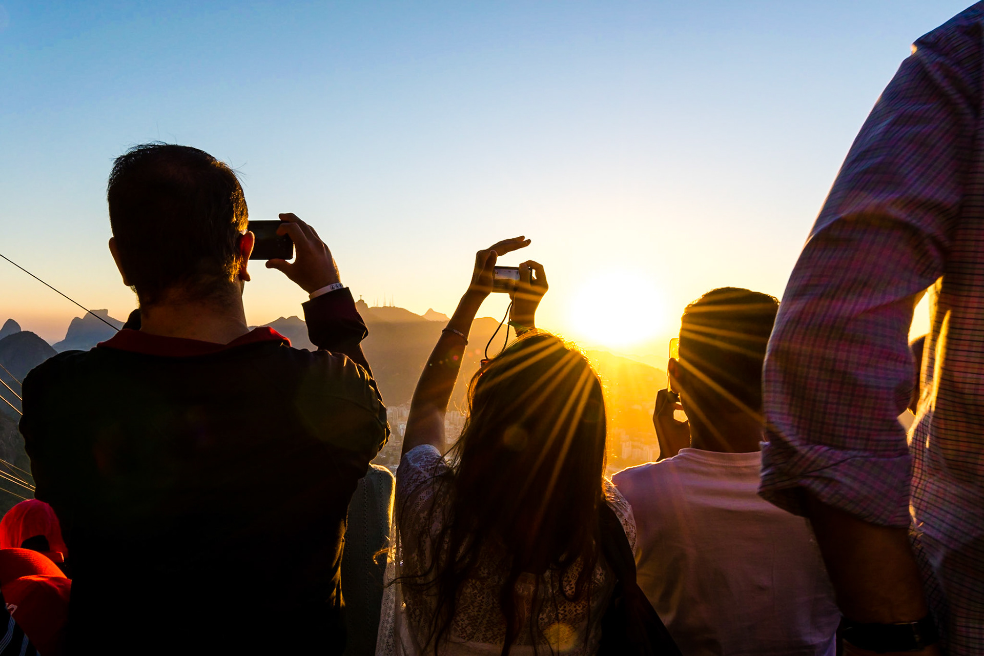 RIO DE JANEIRO, BRAZIL - AUGUST 13 2015: Tourists capture the sunset over Rio De Janeiro from Sugarloaf Mountain.