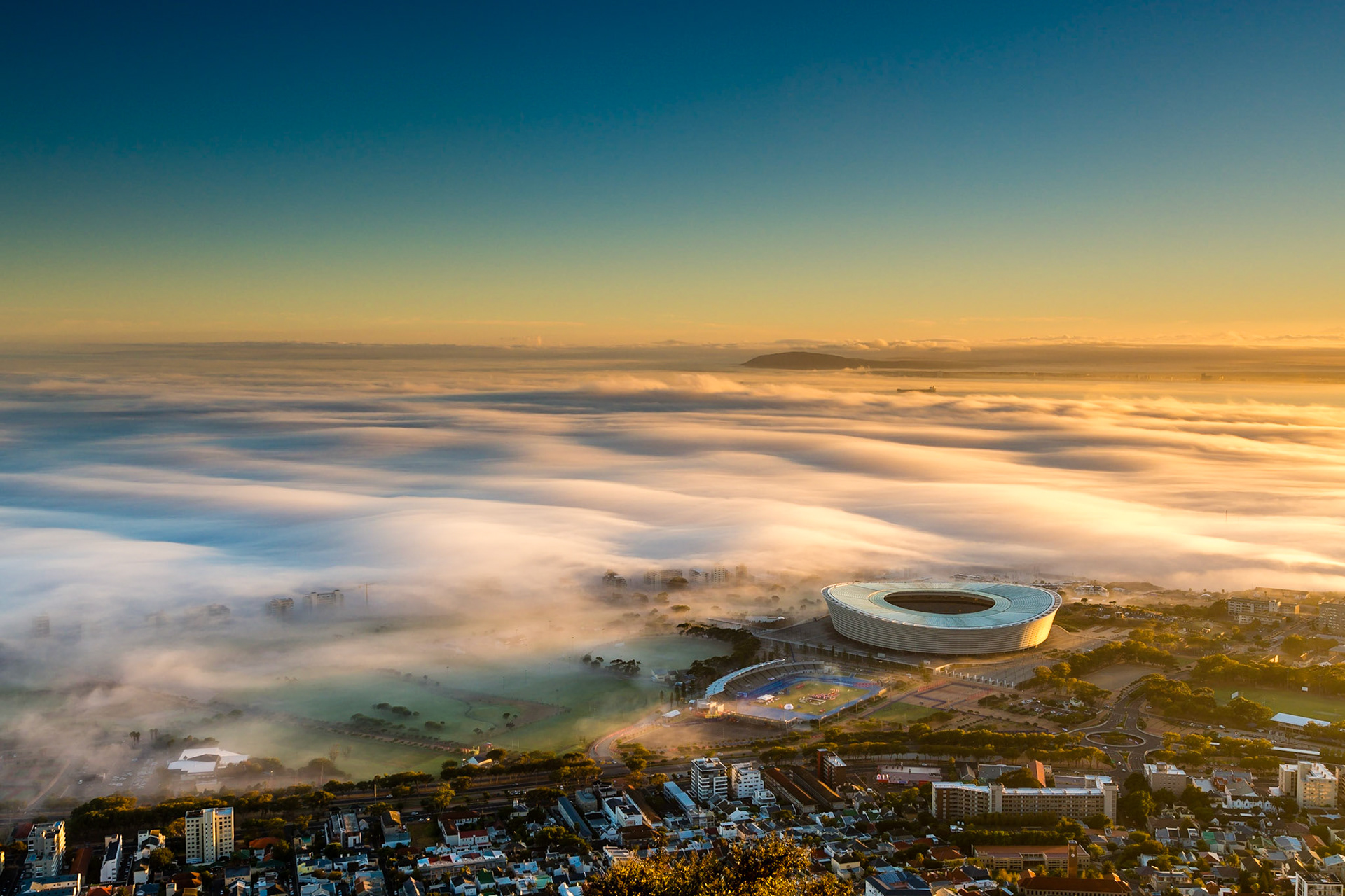 Shortly after sunrise in Cape Town, the fog arrives from the sea and envelops the lower part of the city- including the stadium.