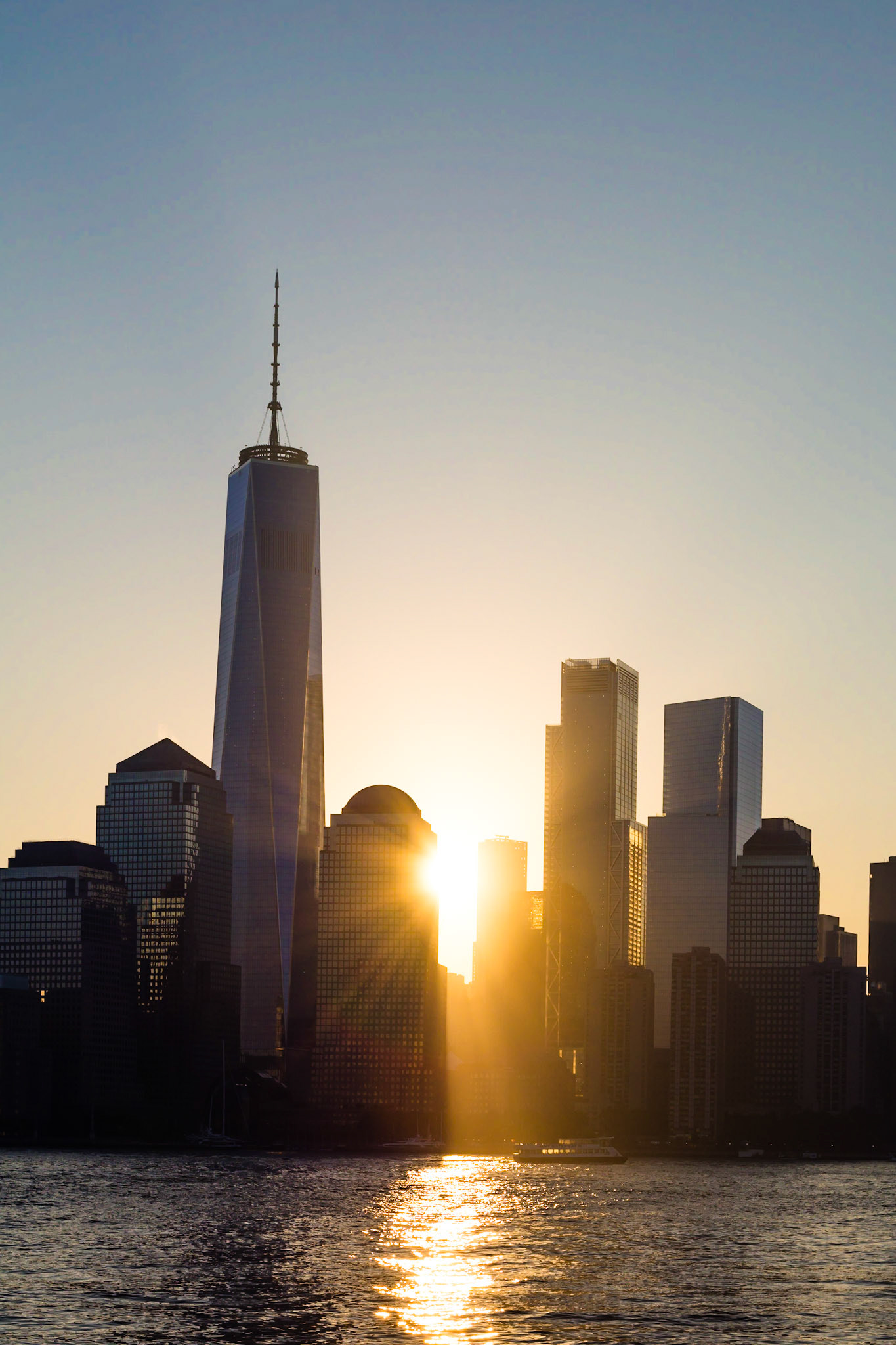 Shafts of sunlight burst from behind the World Trade Center Buildings on Manhattan, New York