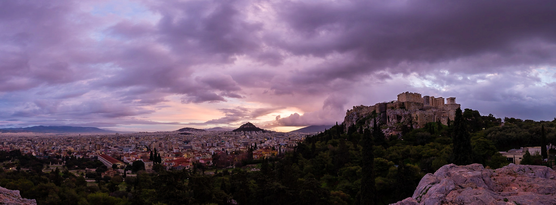 Sunrise in Athens, Greece. Taken from Areopagus Hill, the Acropolis can been seen on the right, Mount Lycabettus in the centre, and the Stoa of Attalos on the far left.