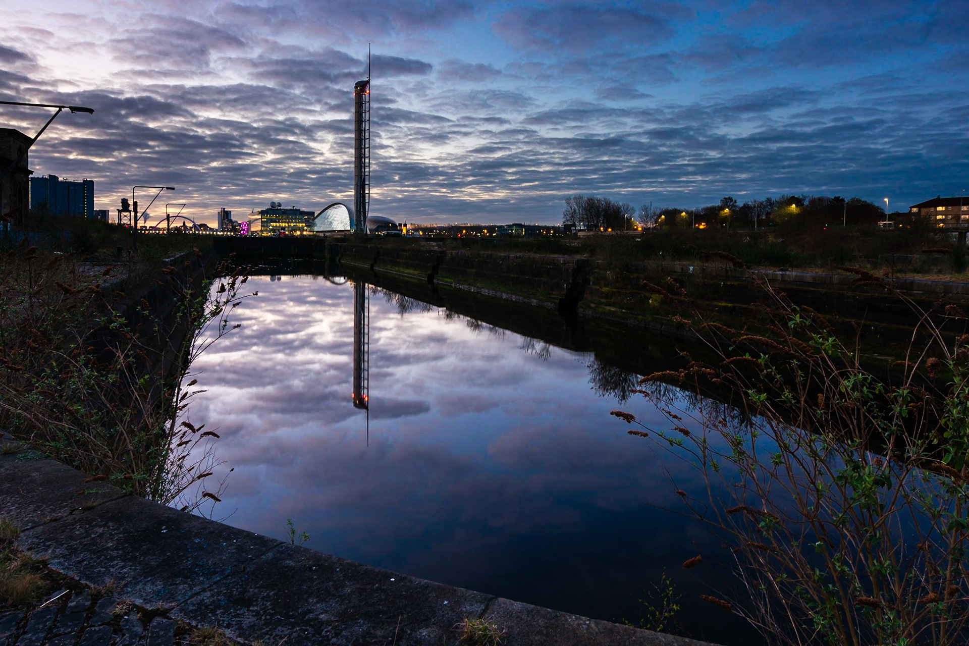 Sunrise over the abandoned and derelict Govan Dry  Docks inGlasgow, UK. The view looks towards the regenerated area of Pacific Quay, including the Glasgow Tower and BBC Scotland office.