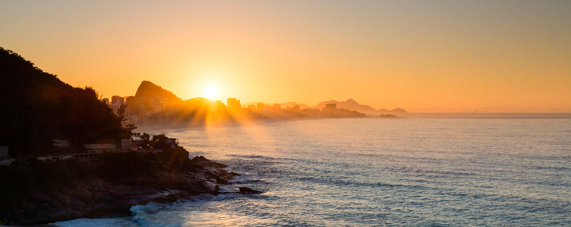 Sunrise in Rio, capturing Ipanema Beach, the town of Leblon and Sugarloaf Mountain.