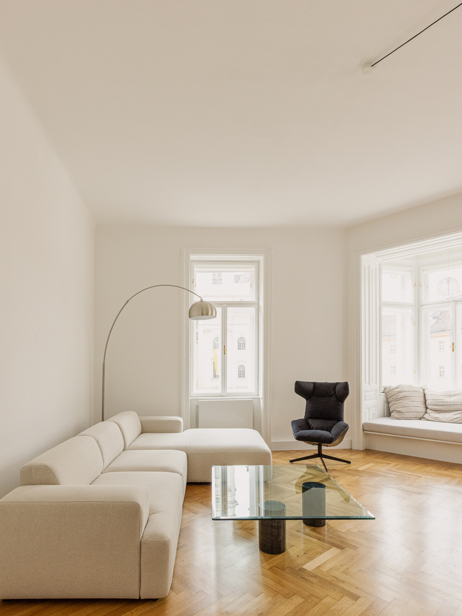 Wohnzimmer mit Glastisch und Erker