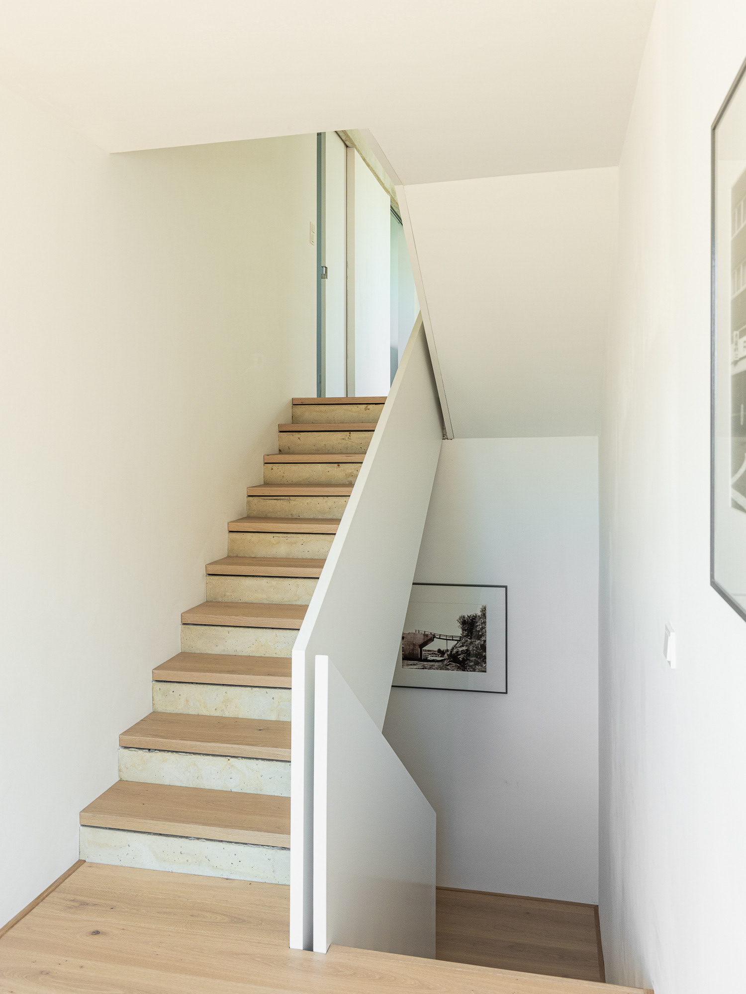 Treppe mit Setzstufen aus Beton und Trittstufen aus Eichenholz