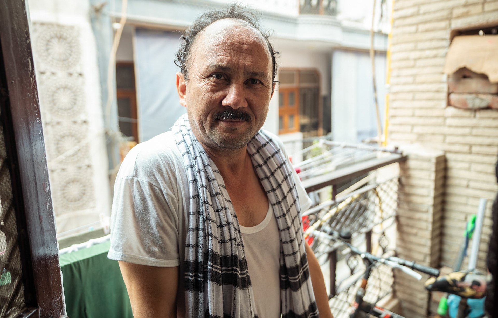 A diffrently abled Afghan refugee, stands at his house entrance in Tilak Nagar, Delhi.